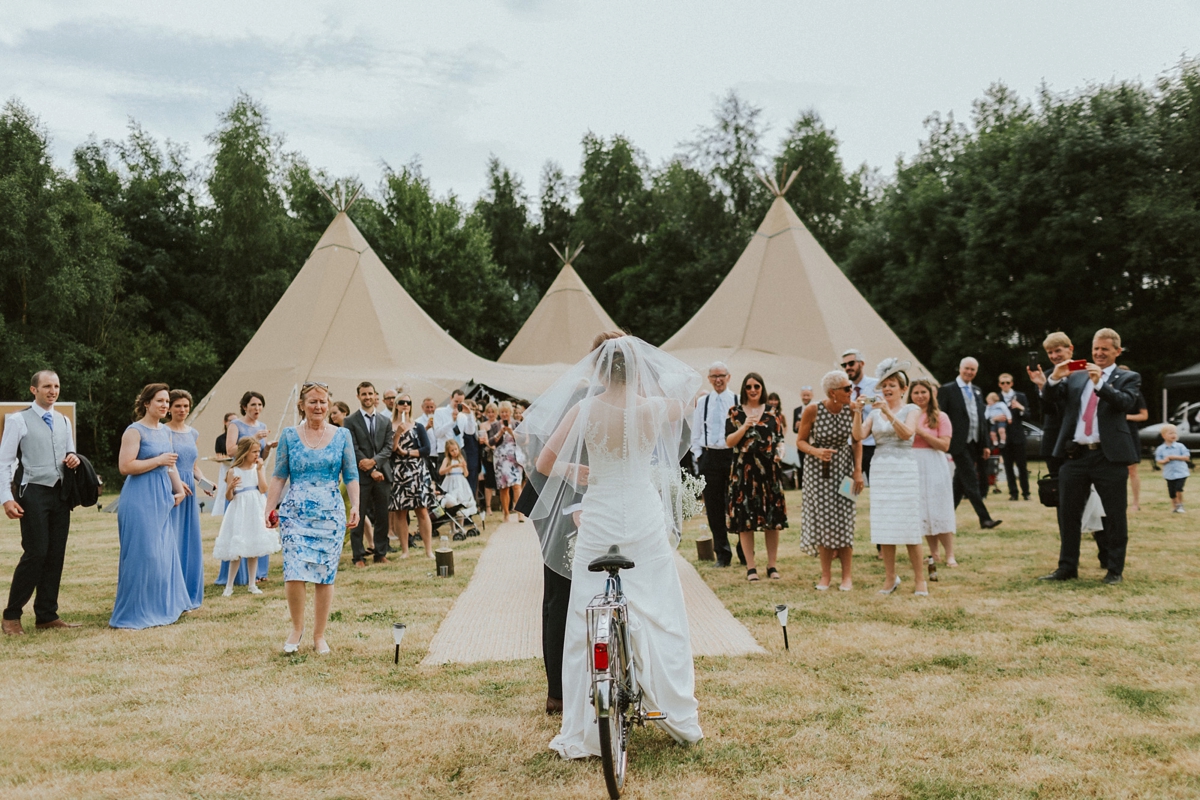30 Couple riding on a tandem to their tipi wedding reception
