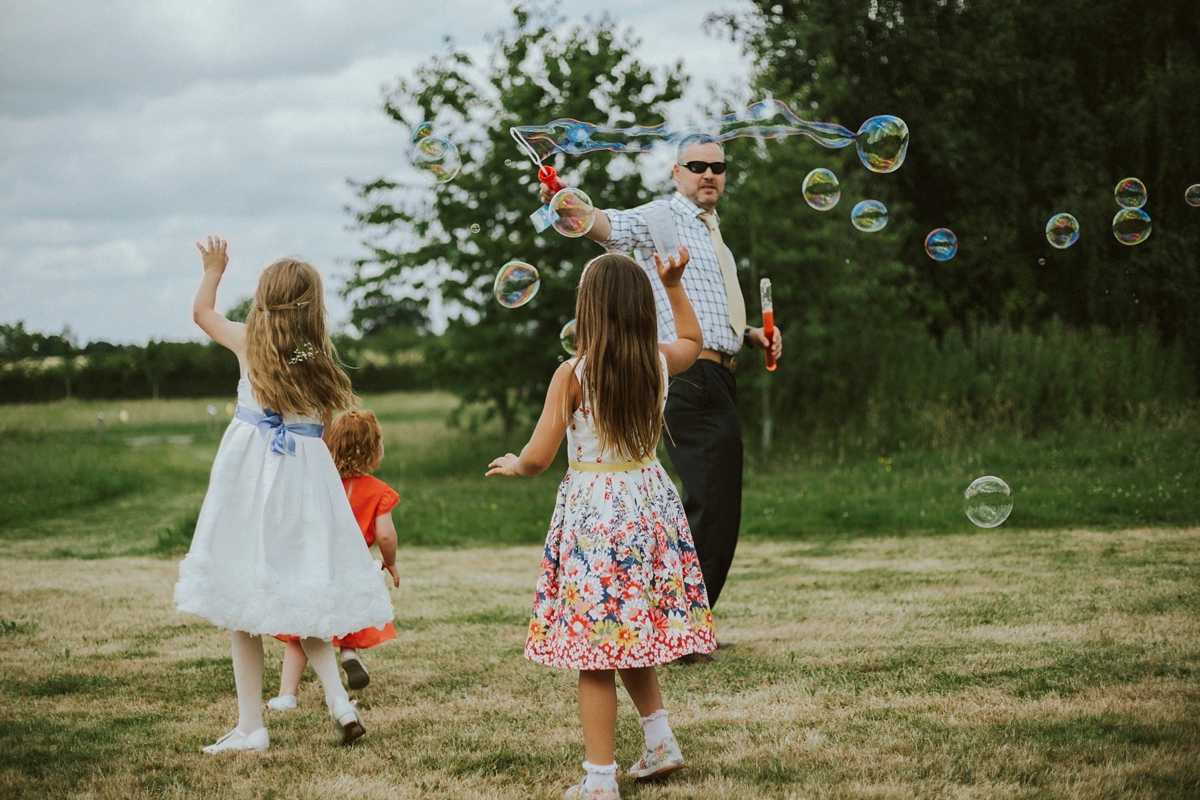 32 Children blowing giant bubbles at a wedding
