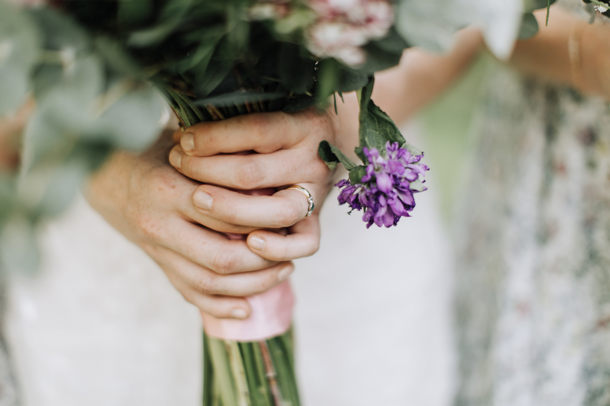56 Brides hands clutching a wedding bouquet