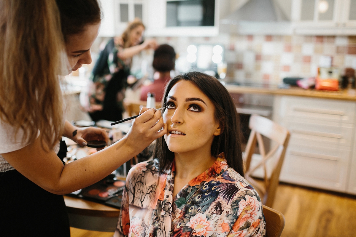 6 Bride with long dark lose hair having her makeup applied