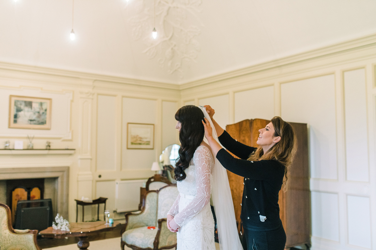 9 Bride with long dark wavy hair wearing a long sleeved Rosa Clara gown