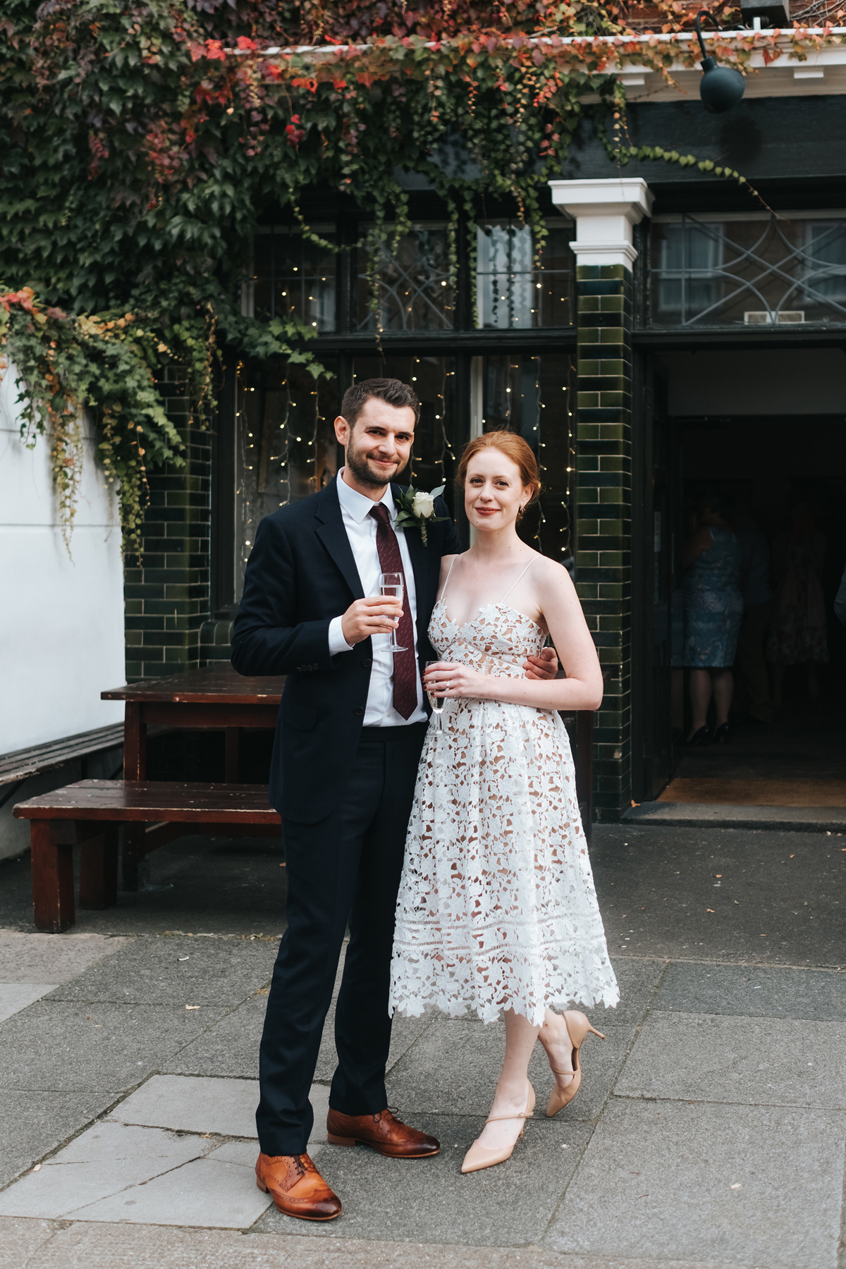 Modern bride and groom pose outside a London pub