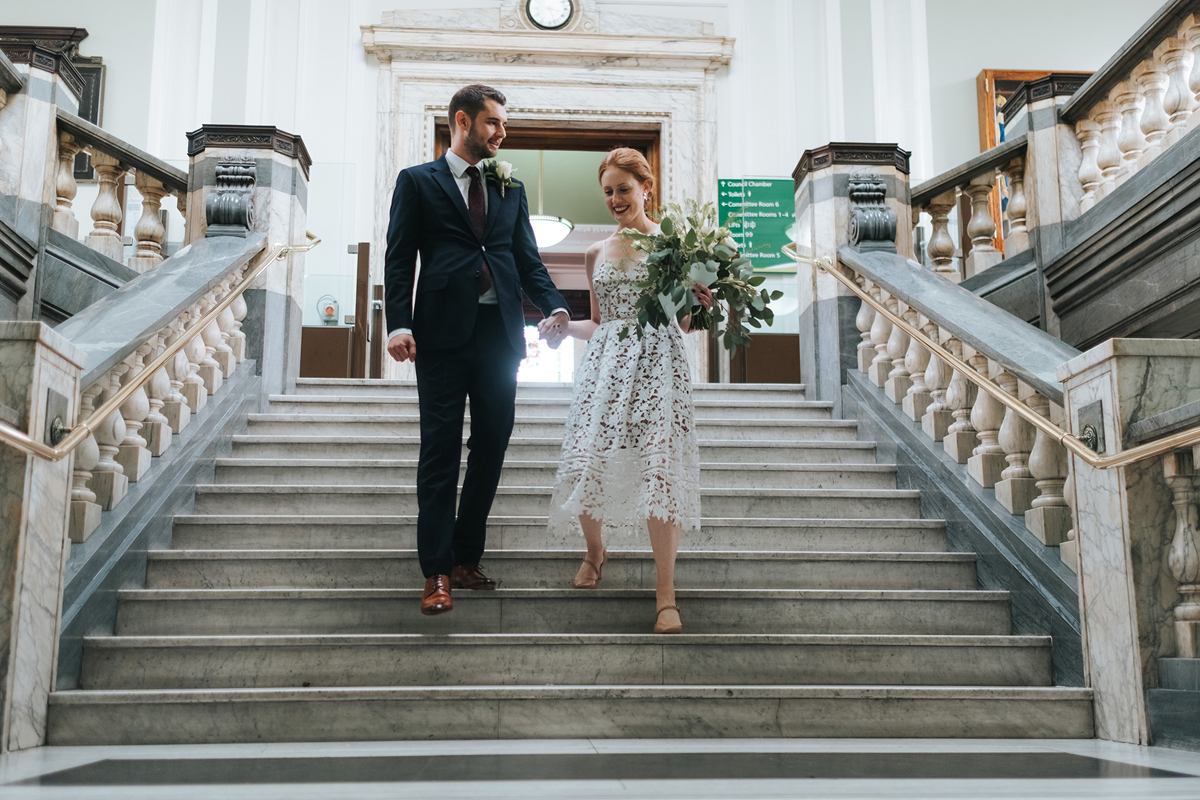 Newlywed couple walking down the stairs at Islington Town Hall