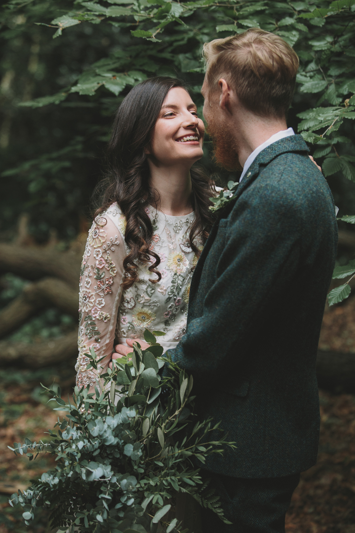 64 Bride in a Needle Thread gown and a Groom with a handlebar moustache and ASOS suit standing in woodland image by McKinley Rodgers
