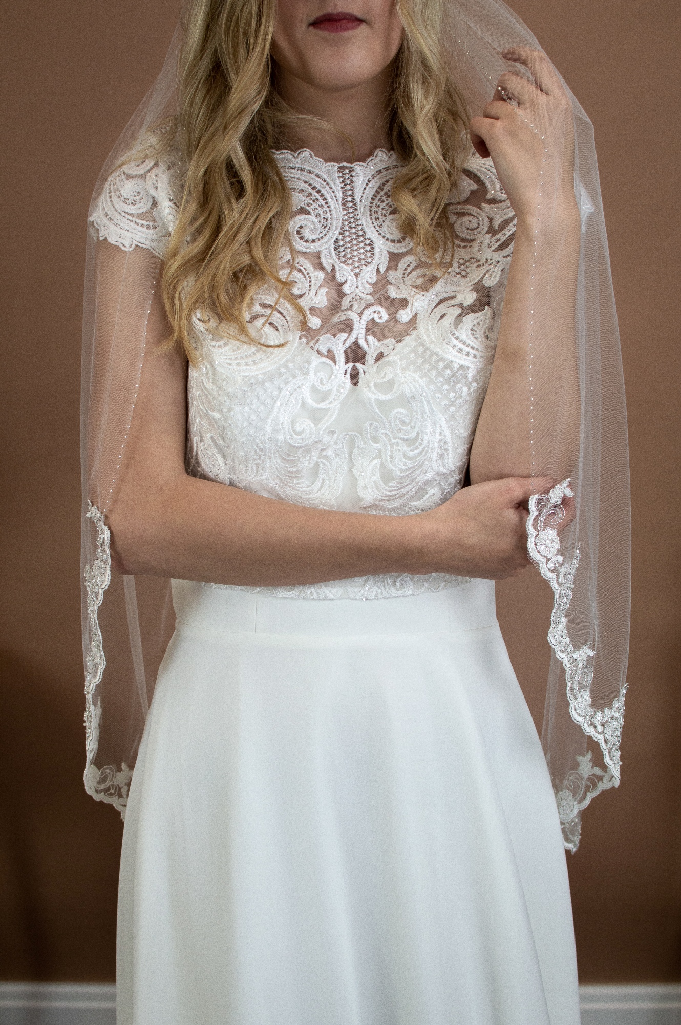 Alana single layer hip length veil with silver and ivory lace topped with a hand beaded edge on a bride font shot