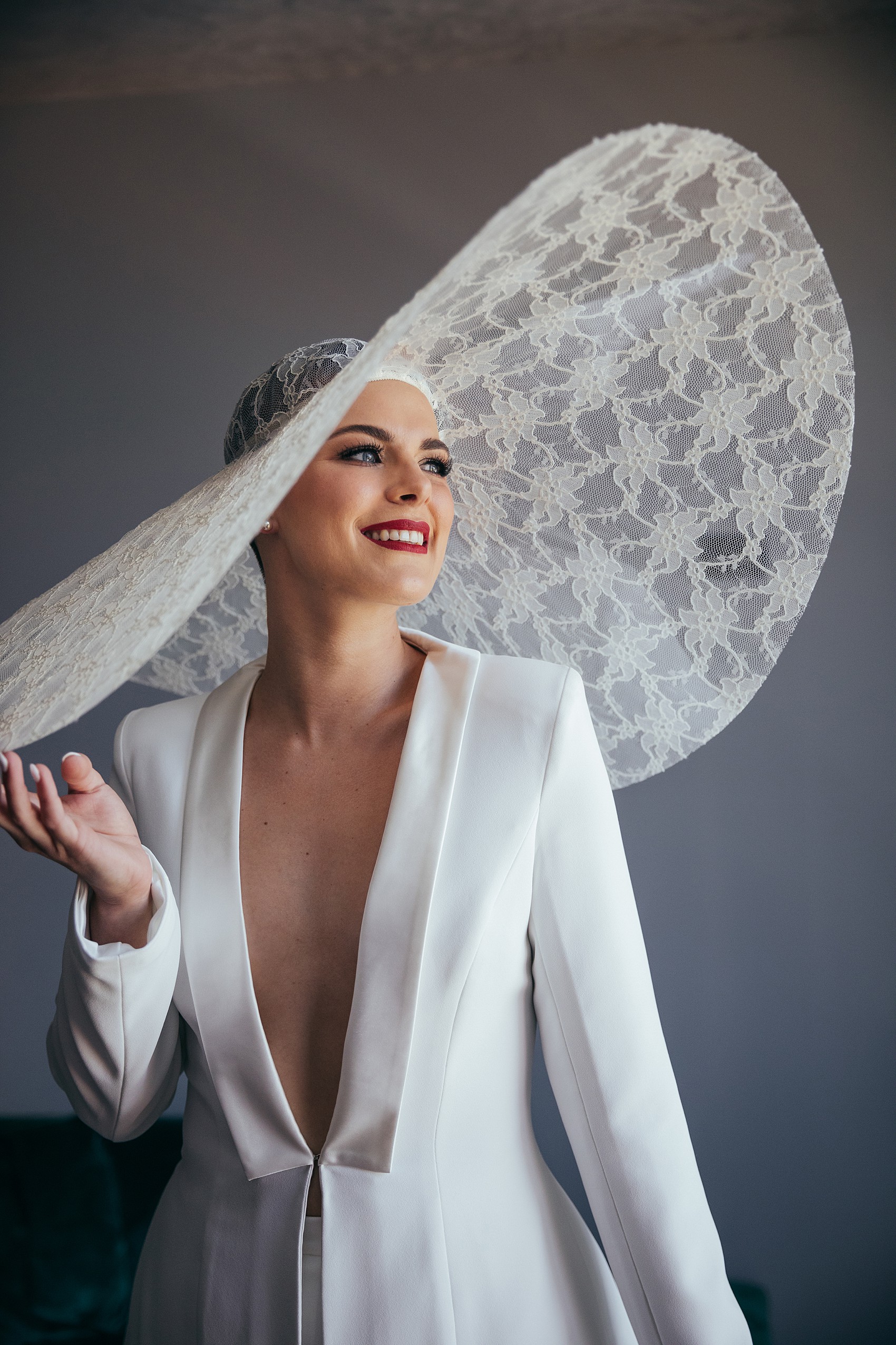 Bride in white tux oversizesd hat 3