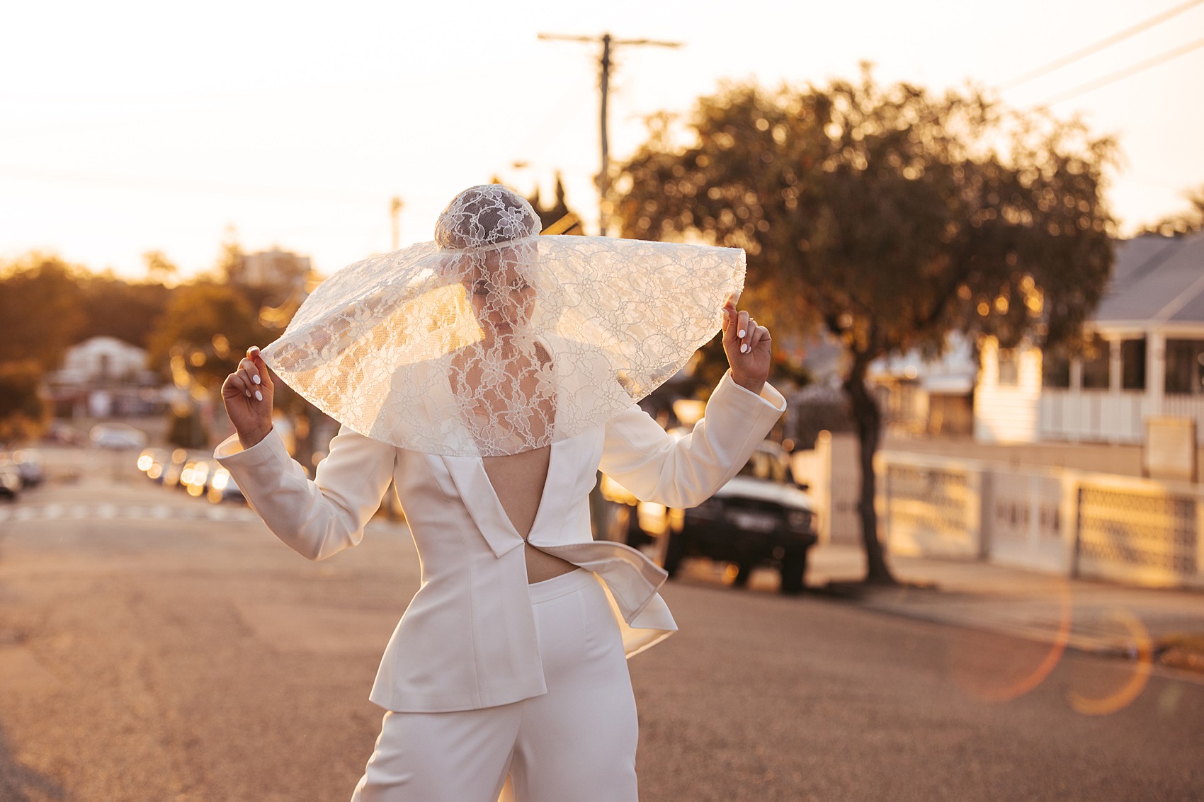 Bride in white tux oversizesd hat 50