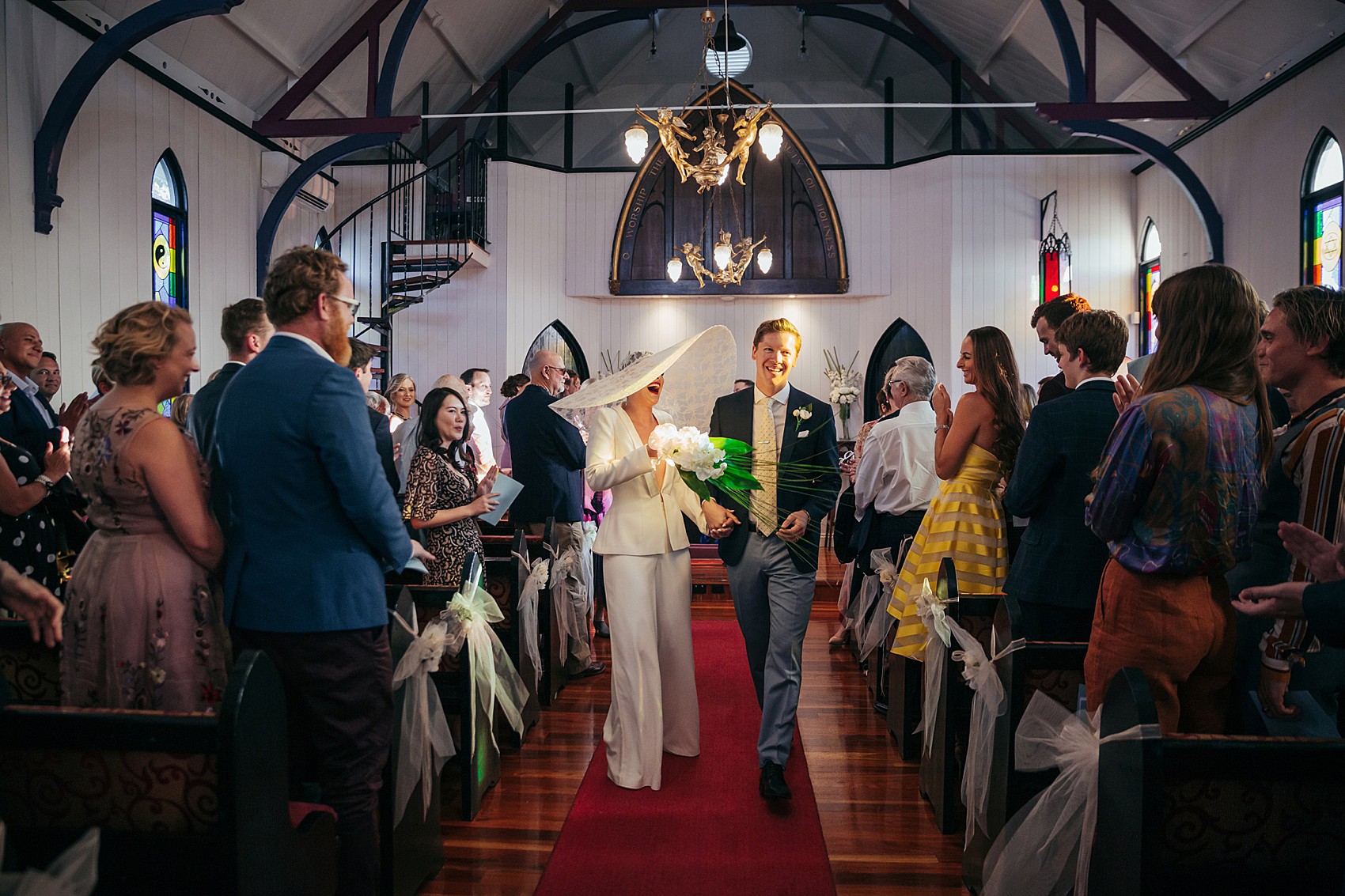 Bride in white tux oversizesd hat 63