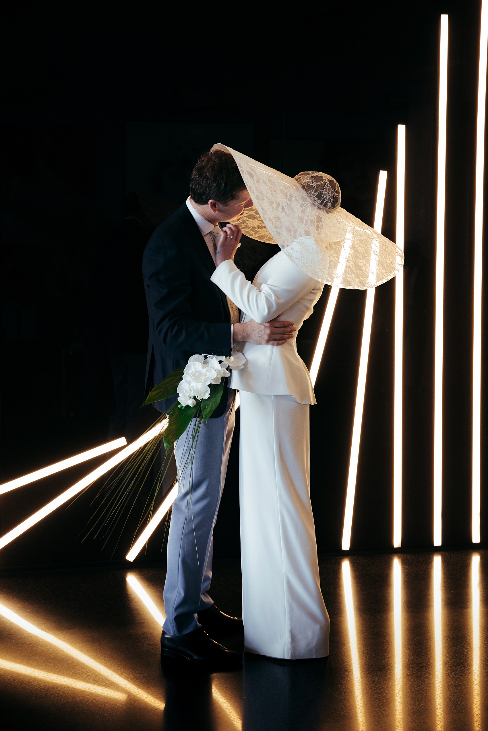 Bride in white tux oversizesd hat 7 1