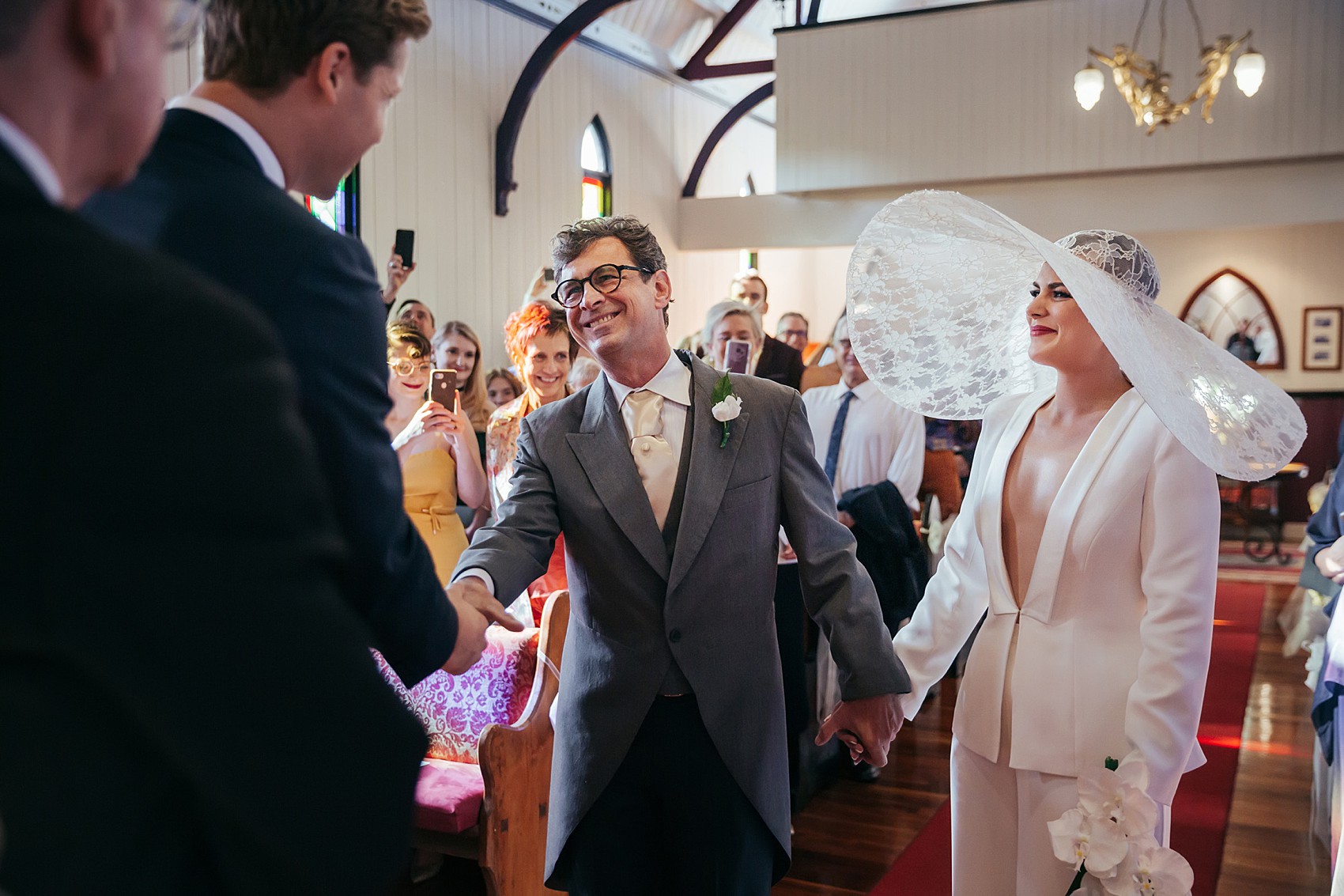 Bride in white tux oversizesd hat 81