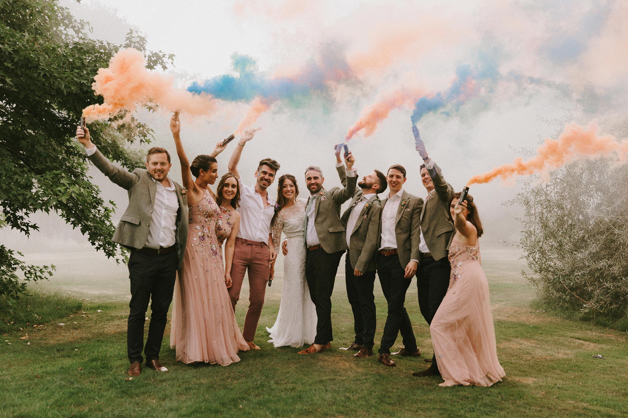 Beautiful Young Man And Woman Hold Light Up Colored Smoke Bombs