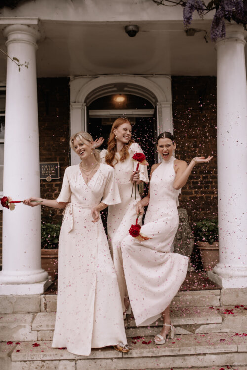 Cream bridesmaids dresses by Maids to Measure. Bridesmaids with red roses.
