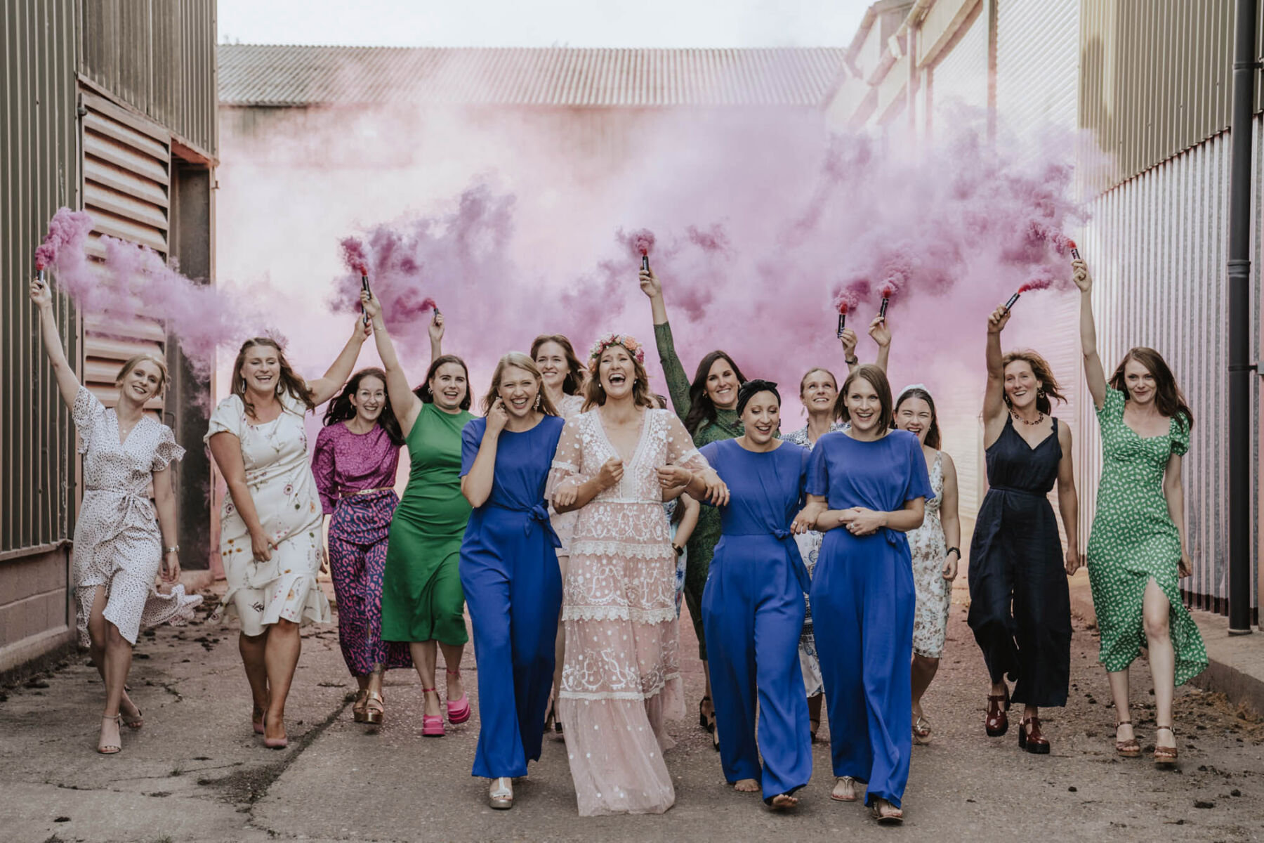 Wedding Smoke bomb. Bridesmaids in blue jumpsuits. Pink Needle & Thread wedding dress.