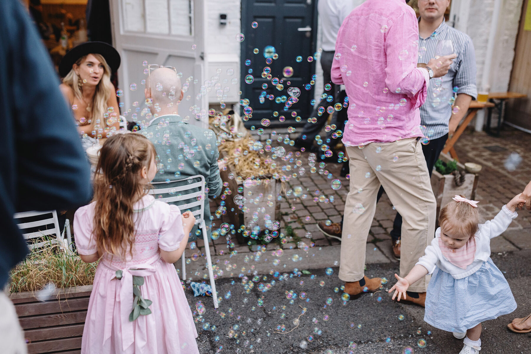 Children blowing bubbles at wedding. Wolf & Co. Photography.