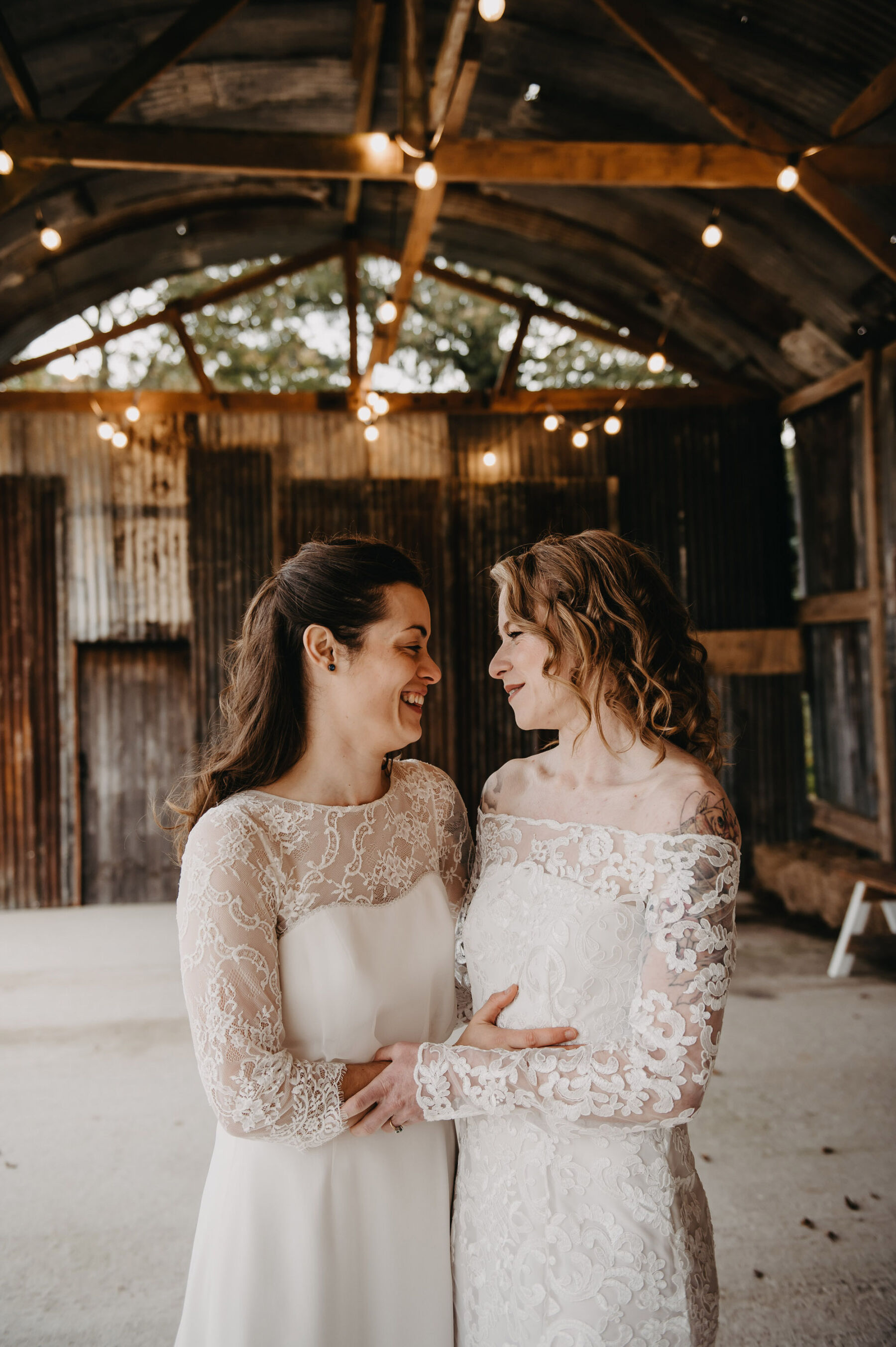 Brides embracing at LGBTQ+ Wedding, Silchester Farm barn venue. Jessica Grace Photography.