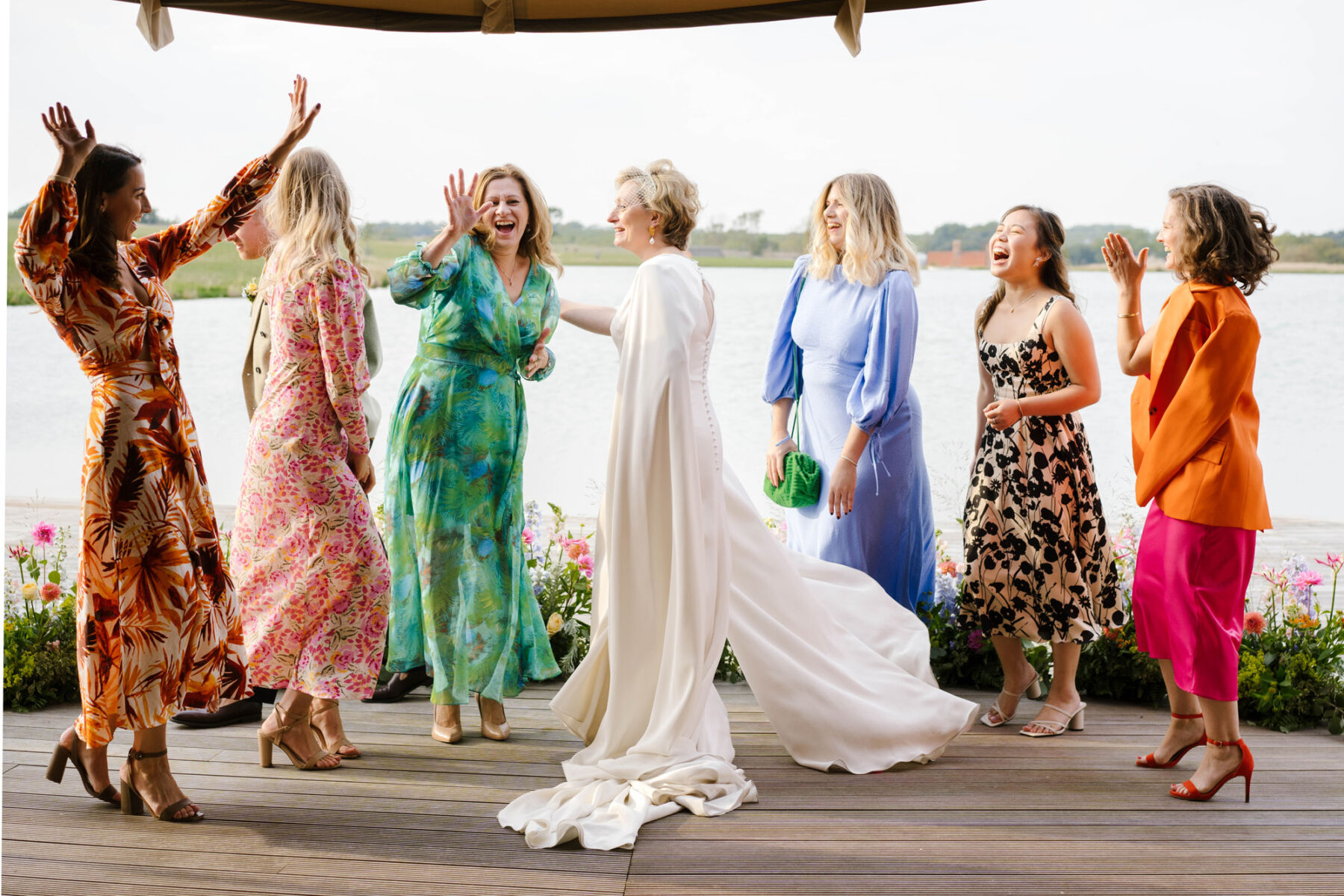Andrea Hawkes bride dancing with guests in colourful wedding dresses