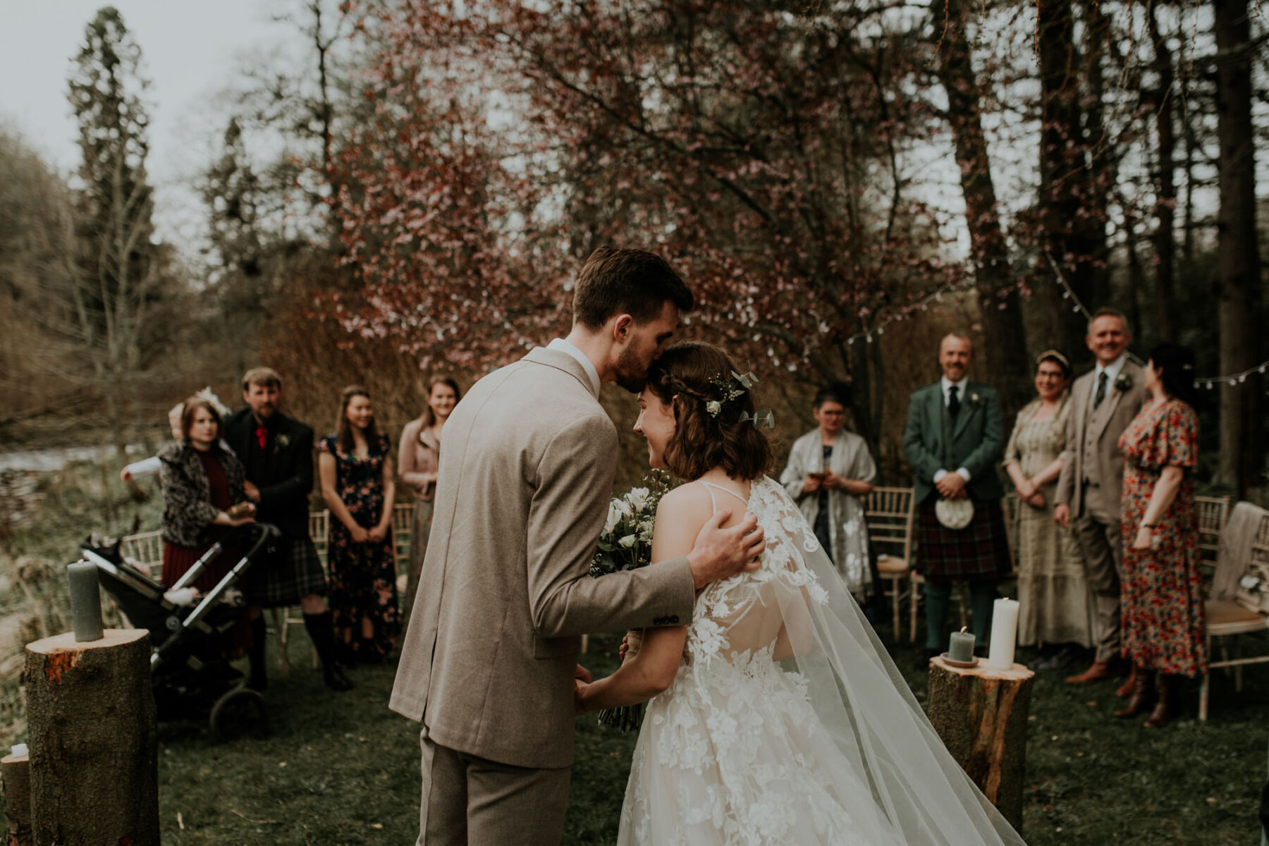 Bride and groom kissing in outdoor wedding ceremony