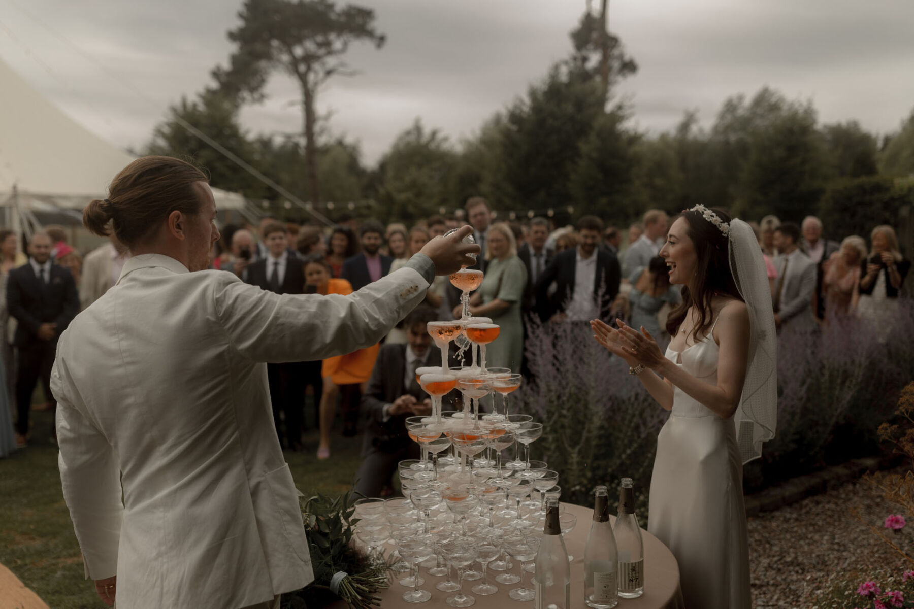 Champagne tower at Scarlet Hall wedding venue, Cheshire. Groom in white suit. Bride in Galvan wedding dress.