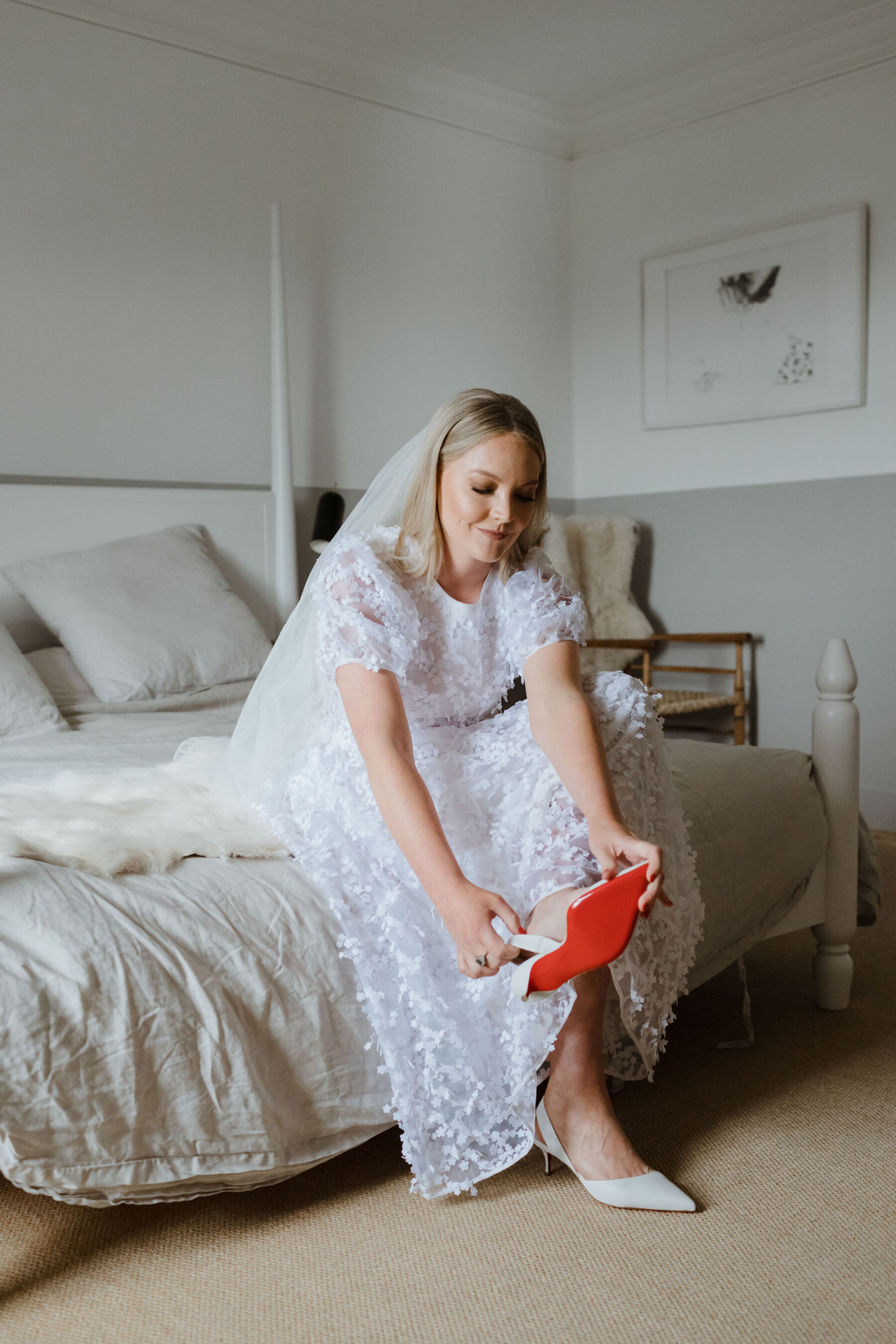 Red undersole of Louboutin wedding shoes. Cecilie Bahnsen wedding dress. Caro Weiss Photography.
