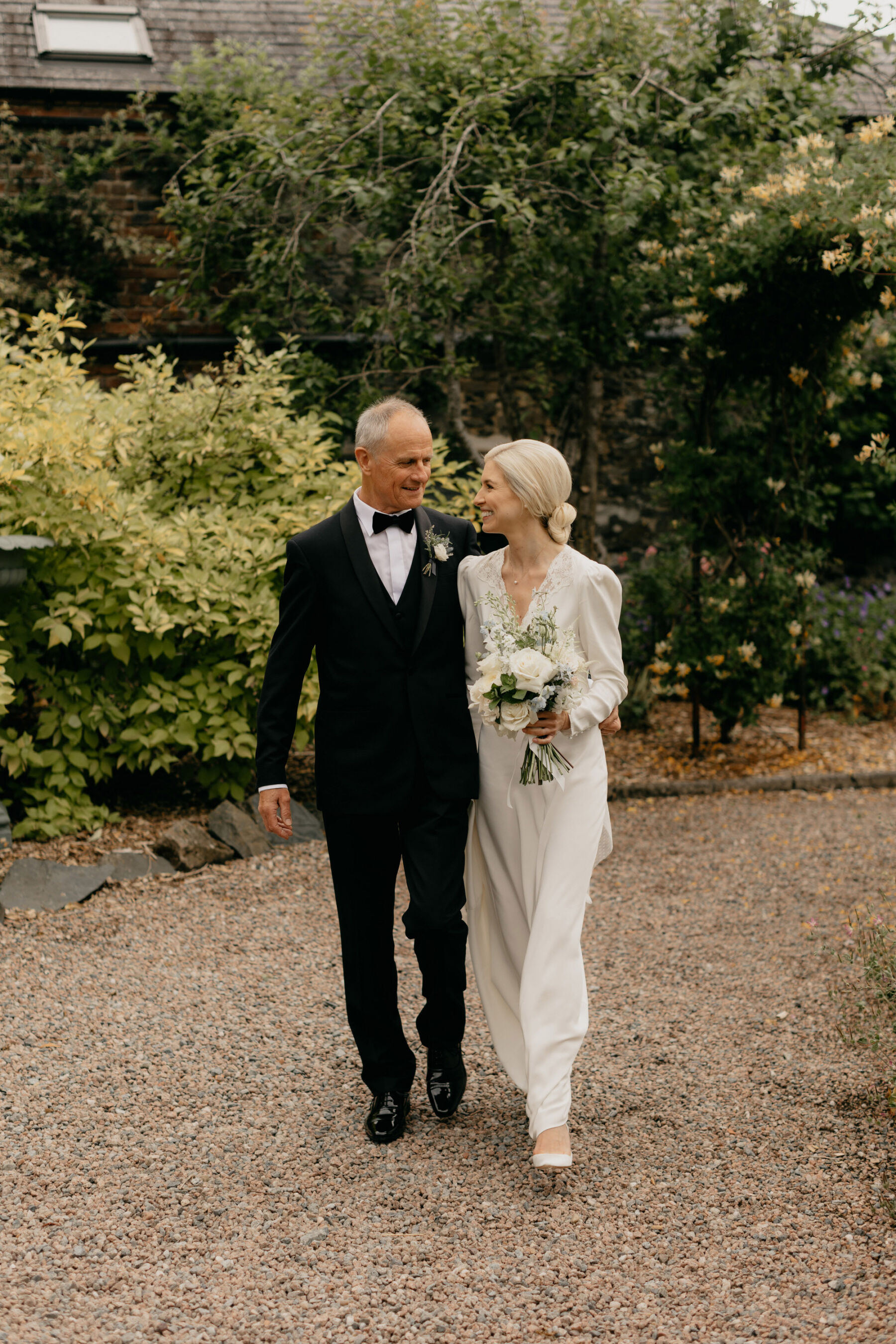 Father of the bride accompanying his daughter wearing a Rixo wedding dress. Larchfield Estate wedding, Northern Ireland.