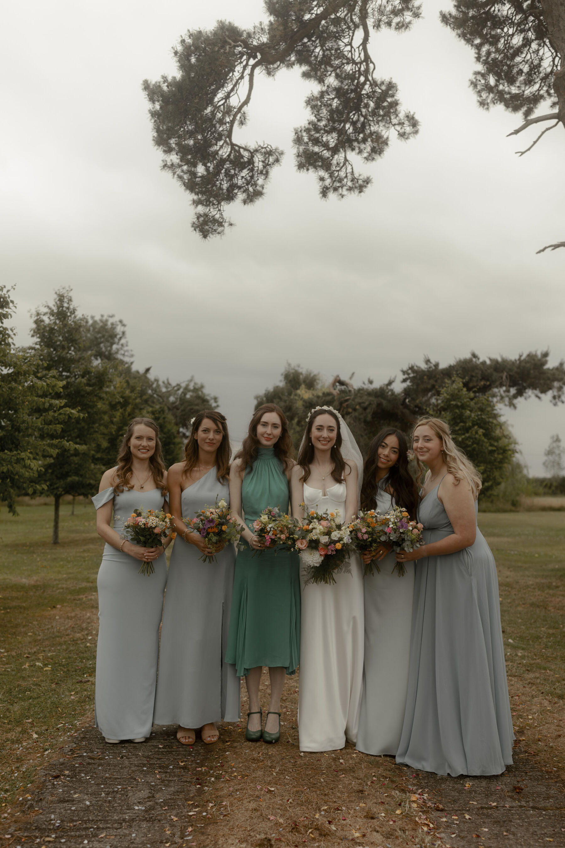 Bridesmaids in pale blue and green dresses.