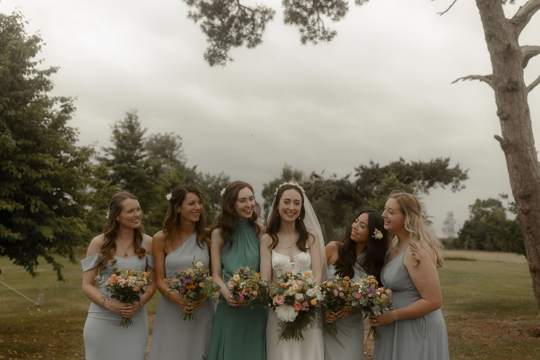 Bridesmaids in pale blue and green dresses.