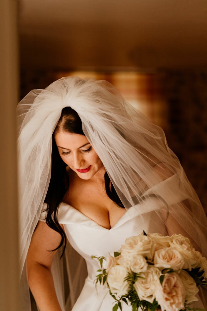 Bride in red lipstick, pouffy veil & Suzanne Nevile Dress, from Miss Bush bridal boutique, Surrey, UK.