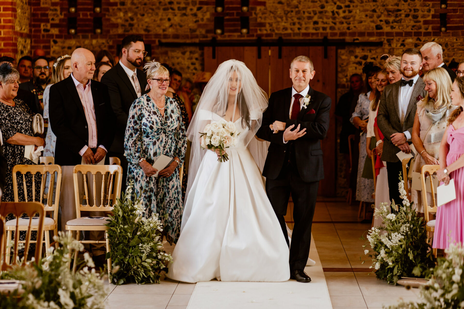 Bride in a Suzanne Neville wedding dress and veil from Miss Bush, bridal boutique, Surrey, UK.