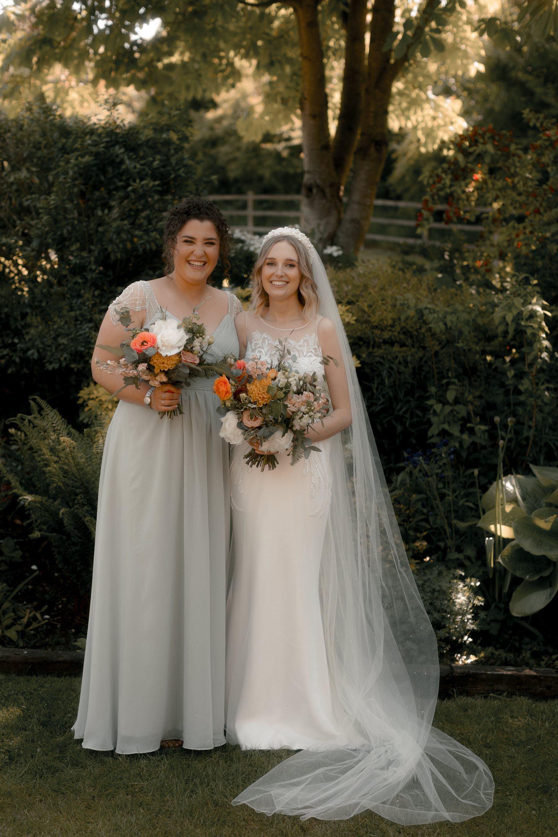 Bride in David Fielden & Bridesmaids in pale grey JJ's house dress. Bright orange wedding bouquets.