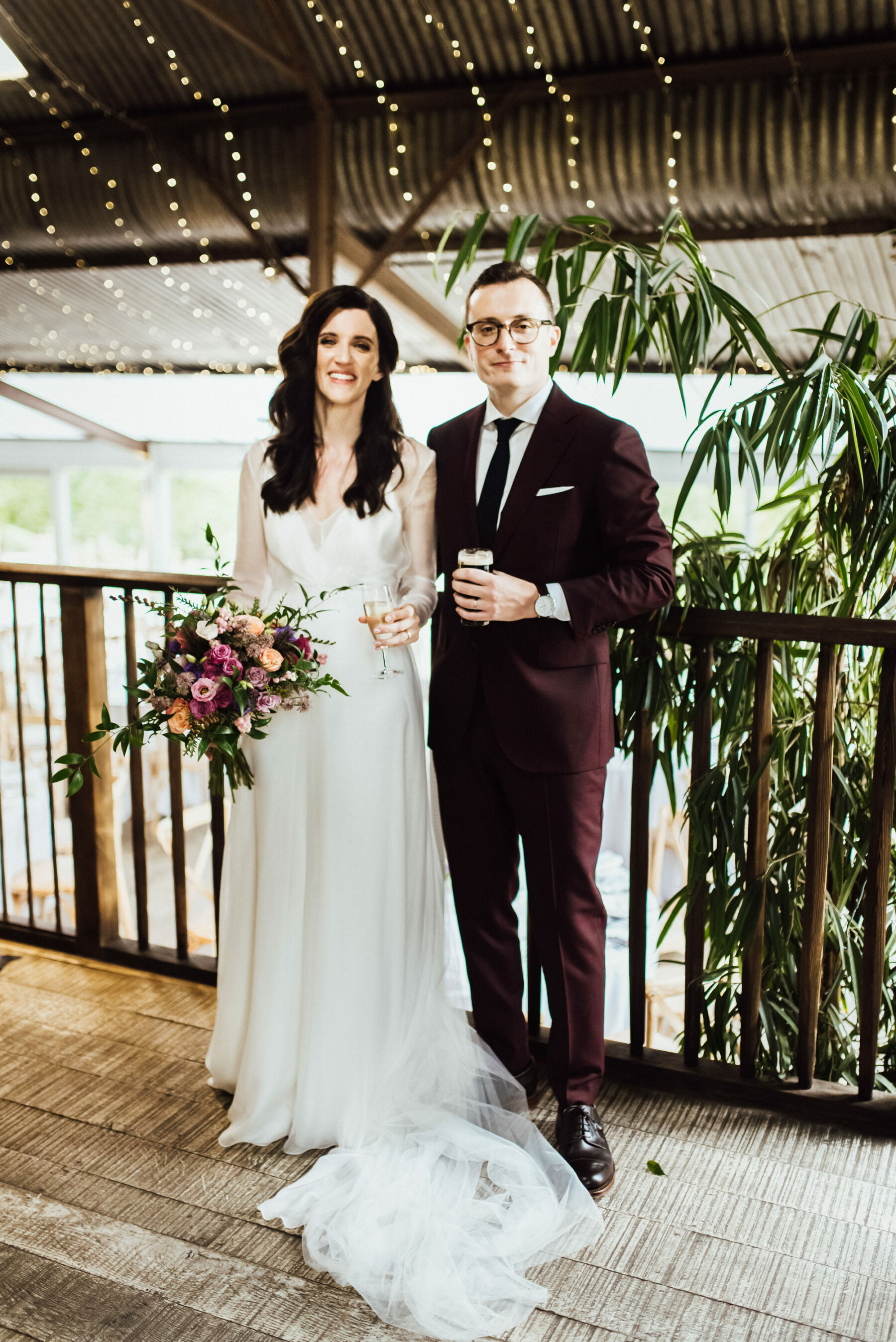 Groom in burgundy suit. Bride in simple & elegant Andrea Hawkes wedding dress. Michelle Wood Photography