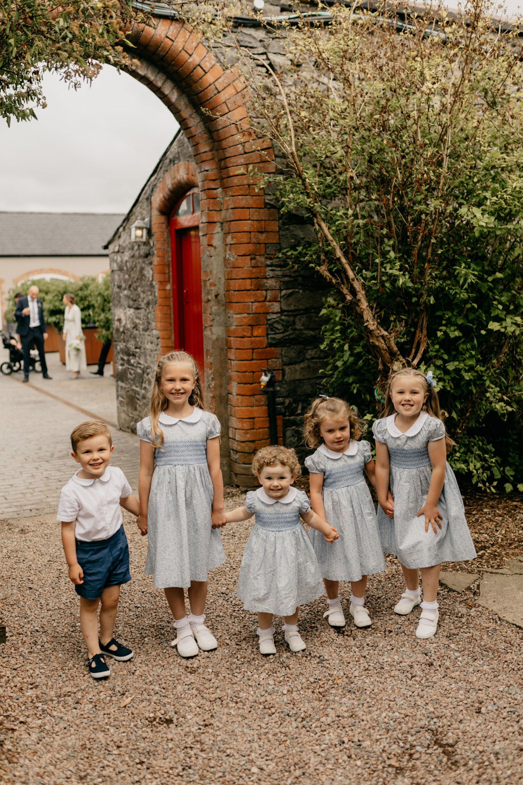 Flower girls in cute pale blue Liberty print dresses with Peter Pan collar. Page boy in shorts and top. All from Trotters Childrenswear.