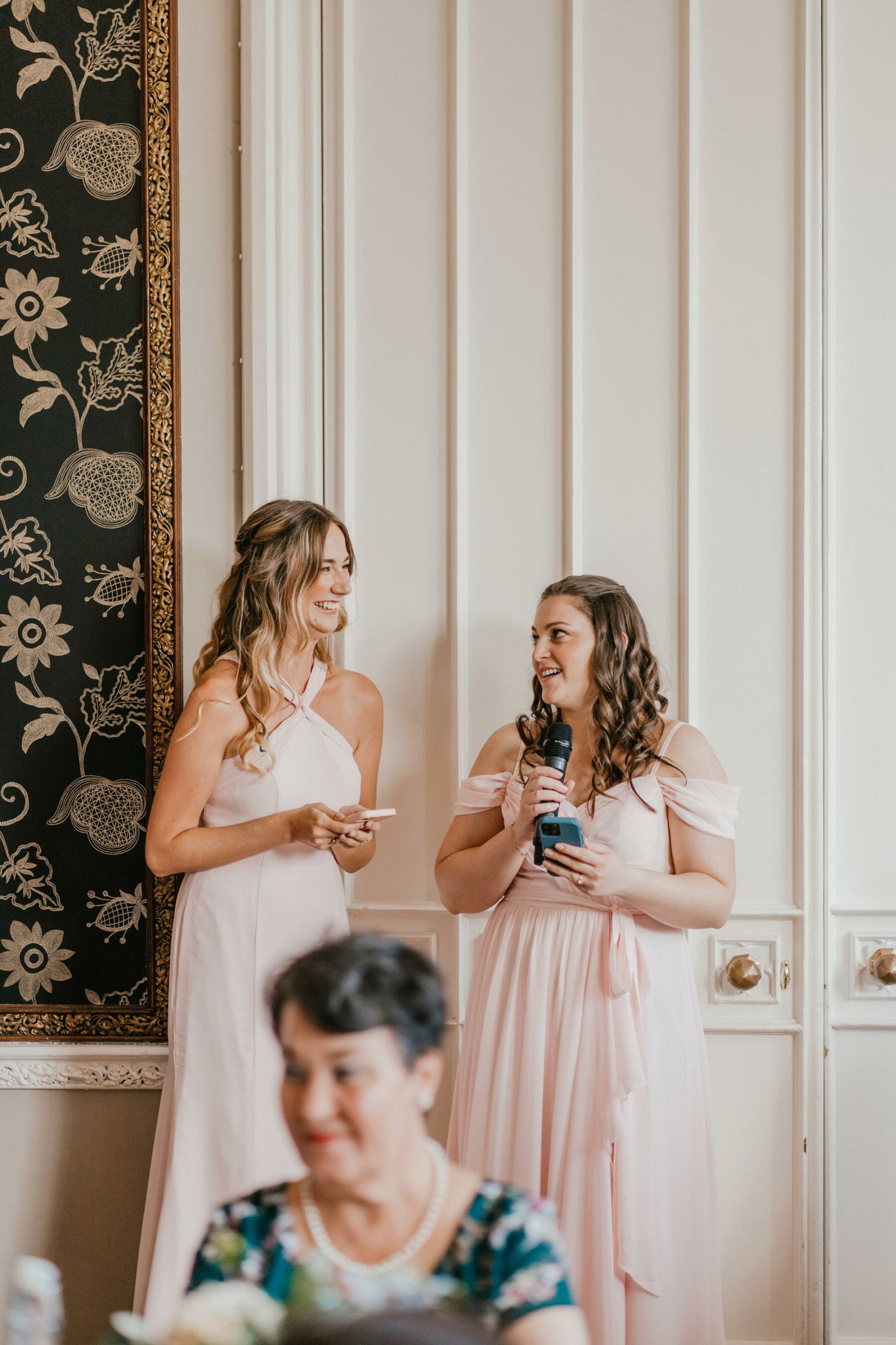 Bridesmaids in pink giving speeches at a wedding. Shelby Ellis Photography.