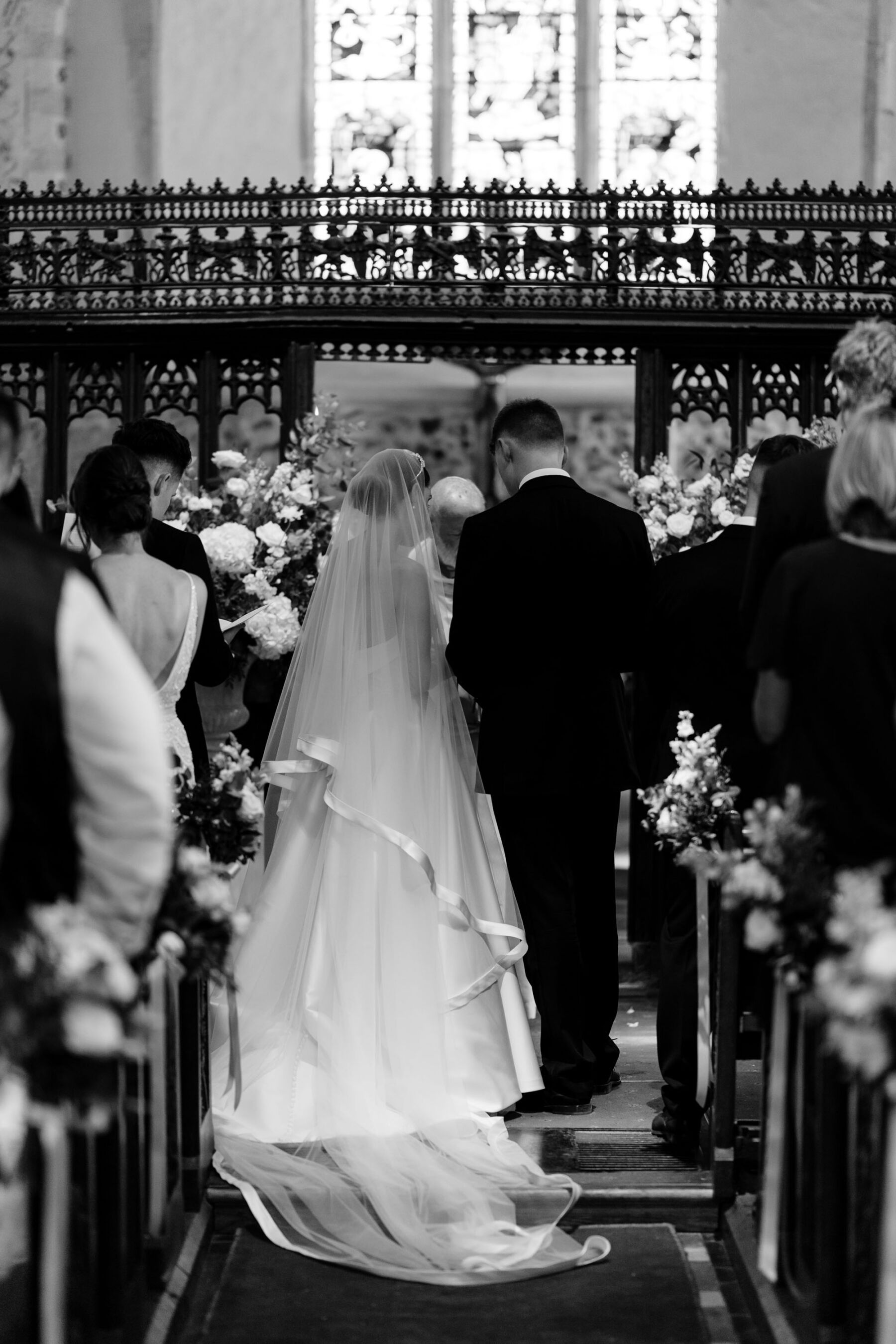 Elegant church wedding ceremony. Bride wears couture Suzanne Neville wedding dress.