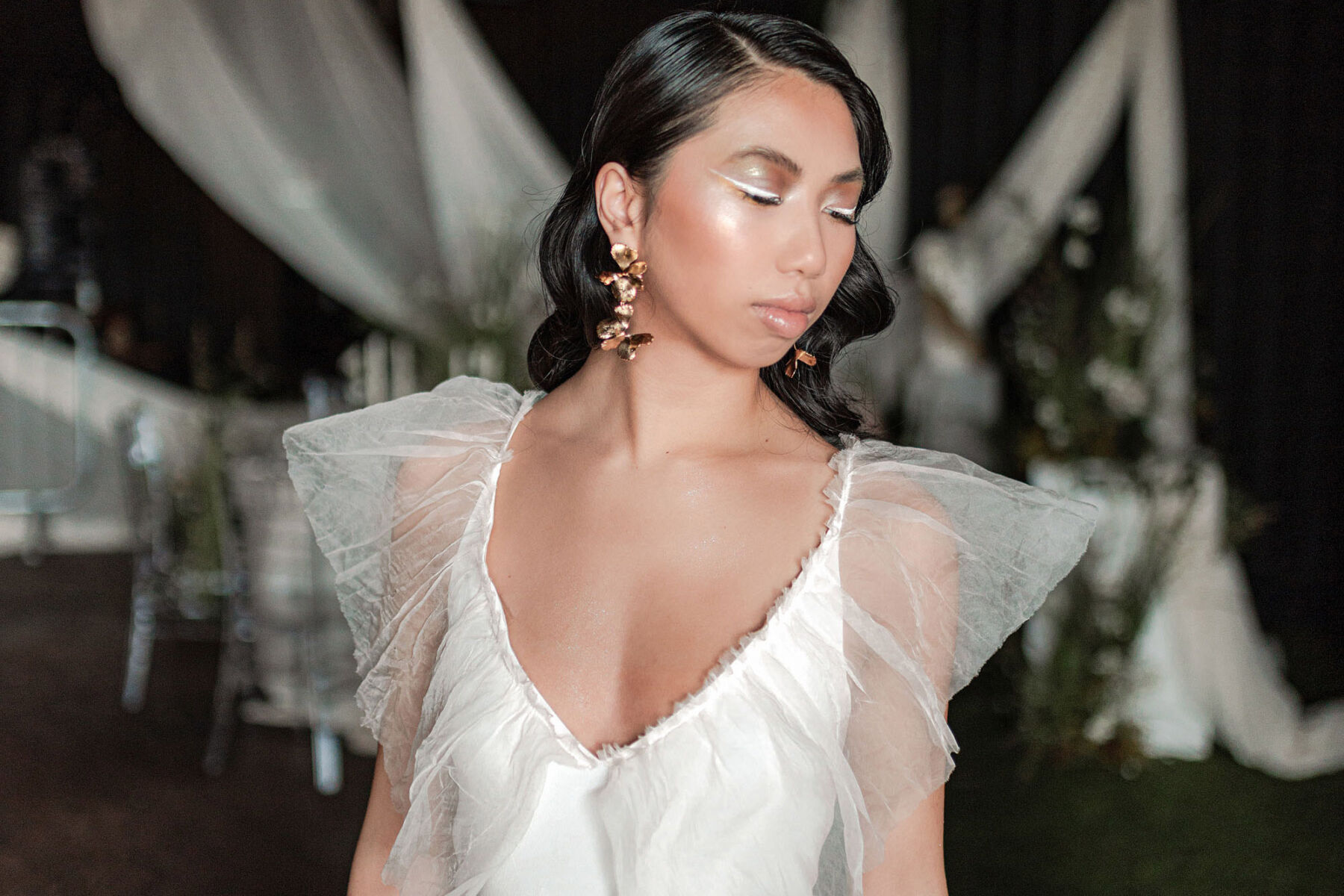 A La Robe modern wedding dress with tulle sleeves. Bride with white eyeshadow.