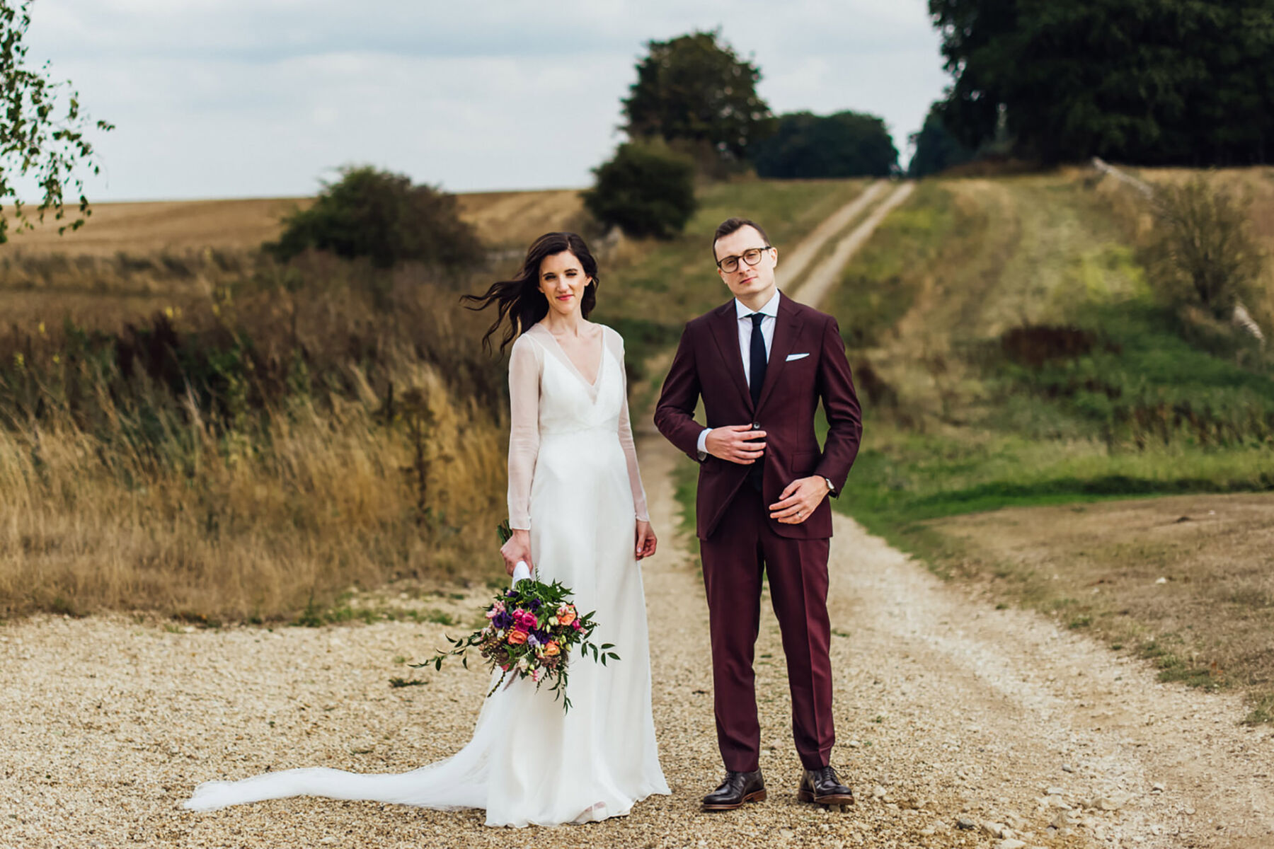 Bride in Andrea Hawkes simple & elegant wedding dress. Groom in burgundy suit. Michelle Woods Photography.