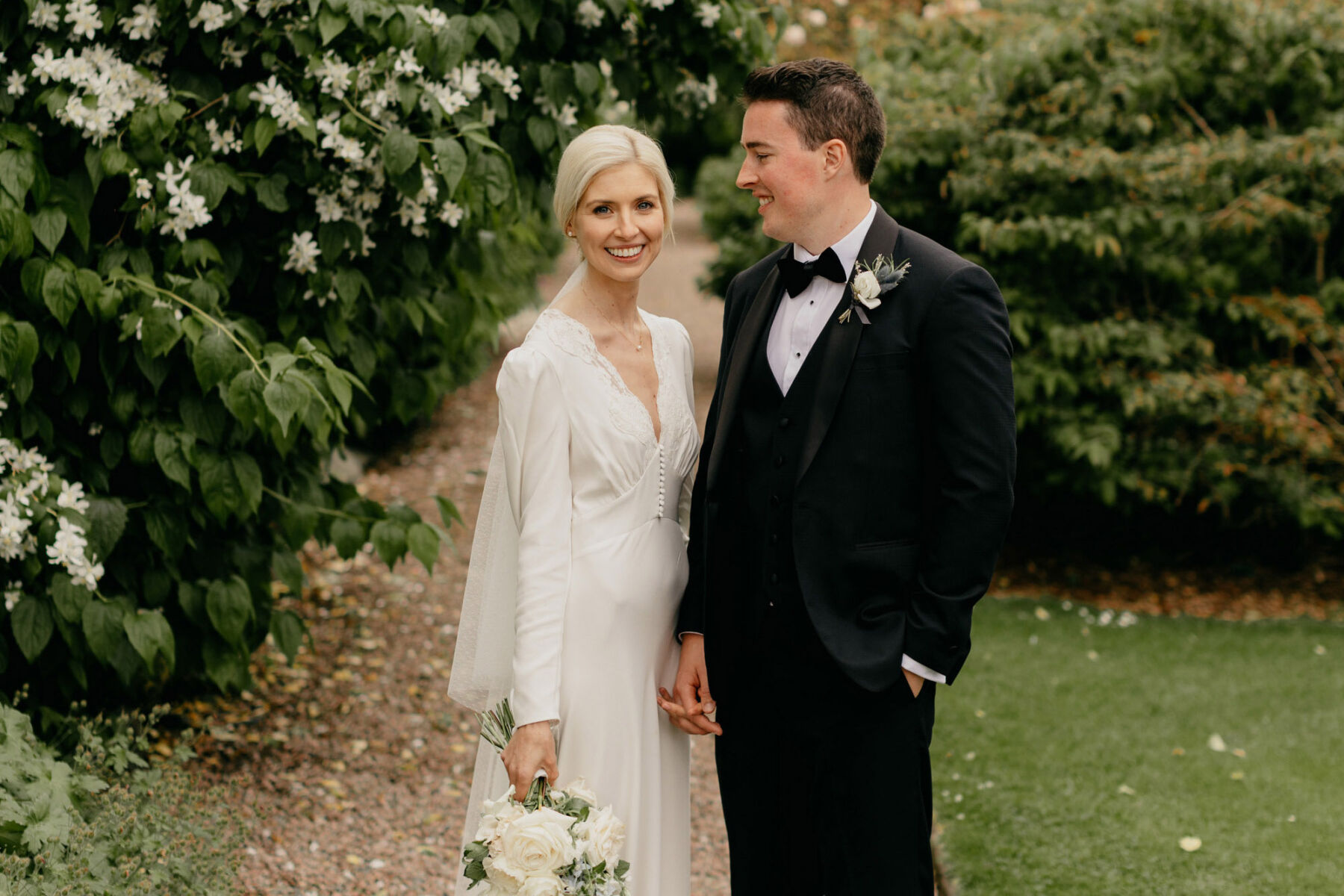 Bride in a Rixo wedding dress & veil. Groom in black tie.