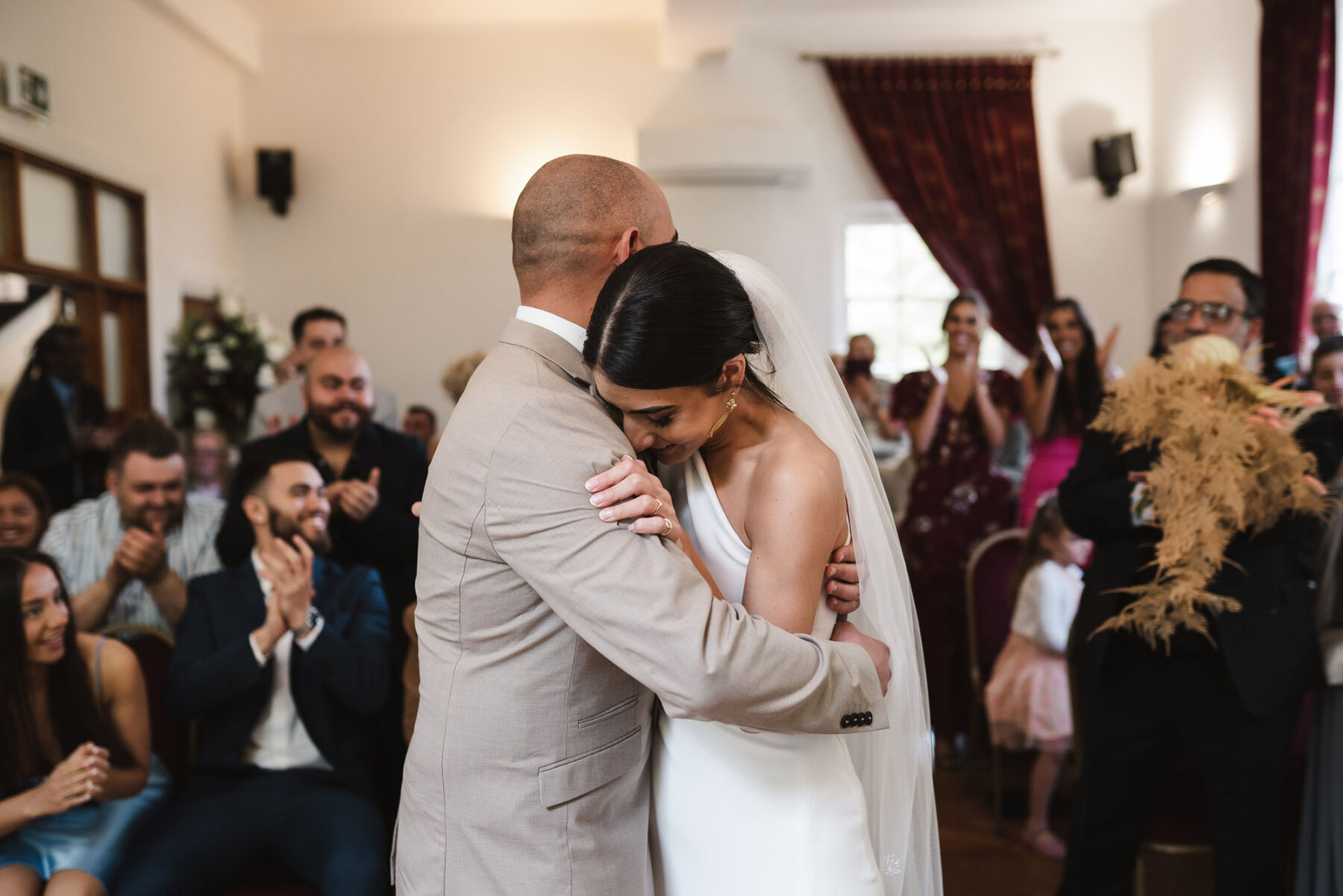 Bride & groom embracing after being declared husband and wife. By Karolina Photography.