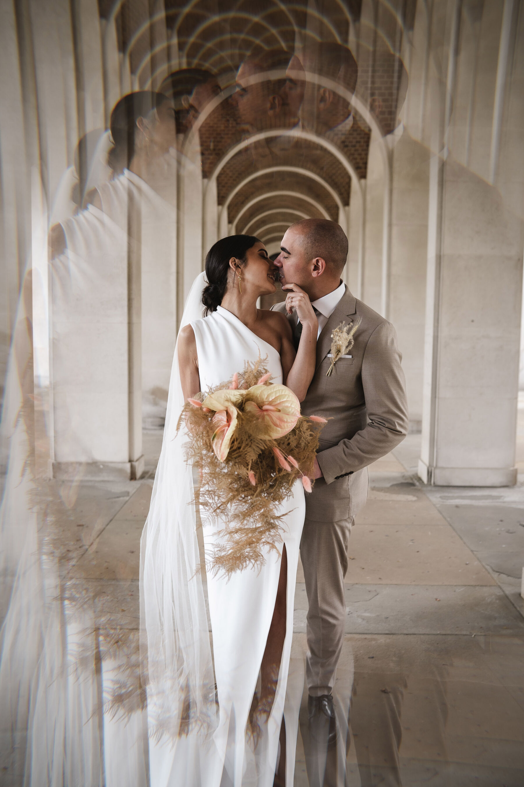 Bride carrying bleached fern bridal bouquet. Solace London wedding dress. By Karolina Photography.