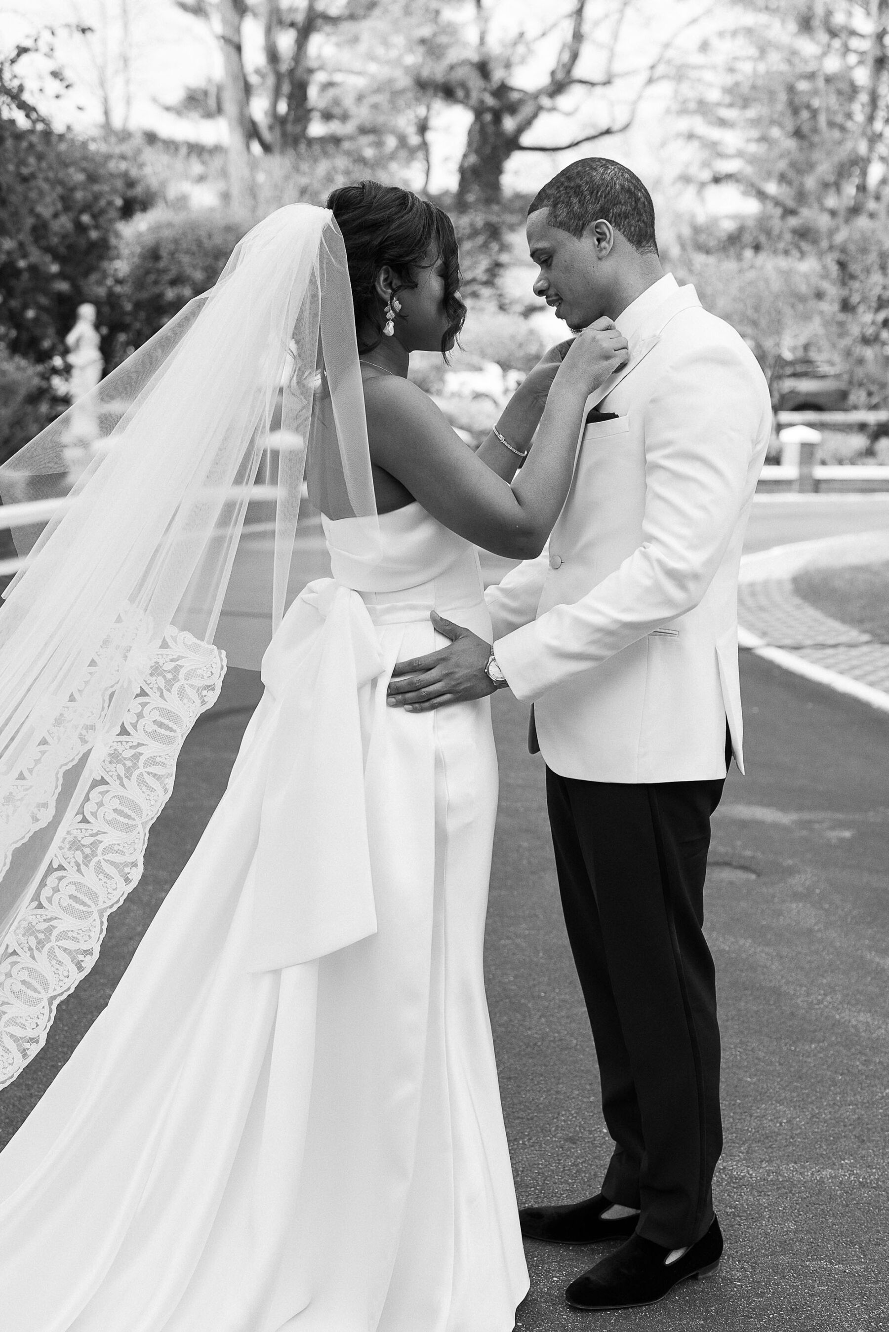 Wedding day first look. Black groom in a white tuxedo. Black bride in Eva Lendel wedding dress.