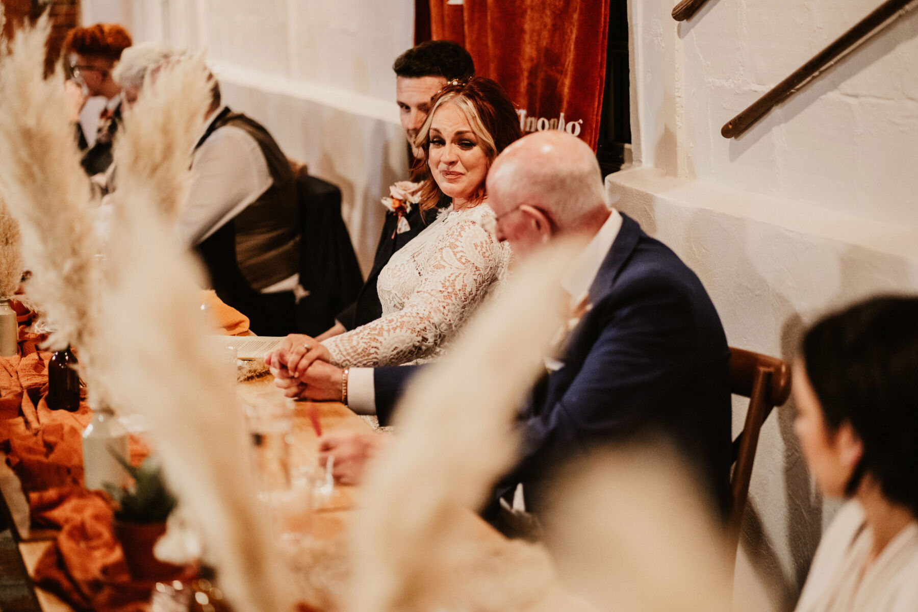 Bride crying happy tears holding her father's hand