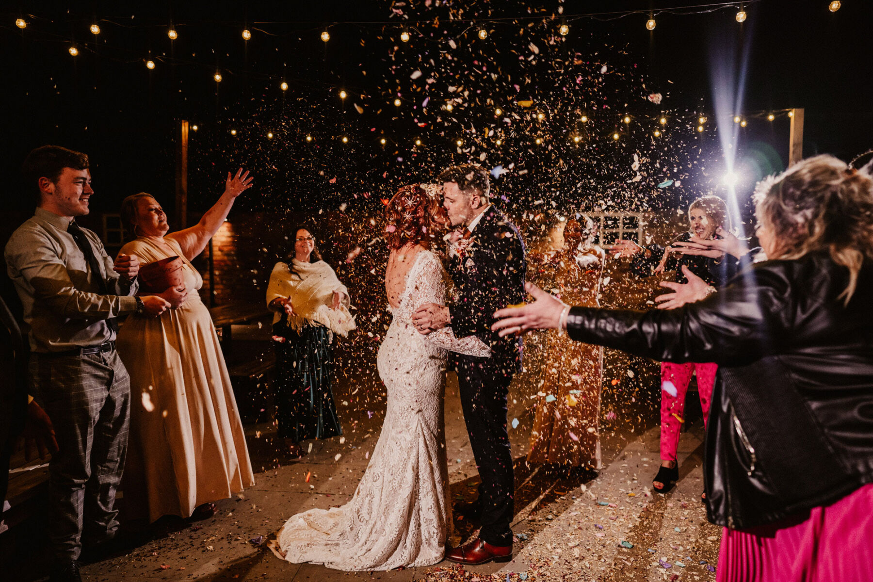 Confetti shower over the bride and groom on the dancefloor.