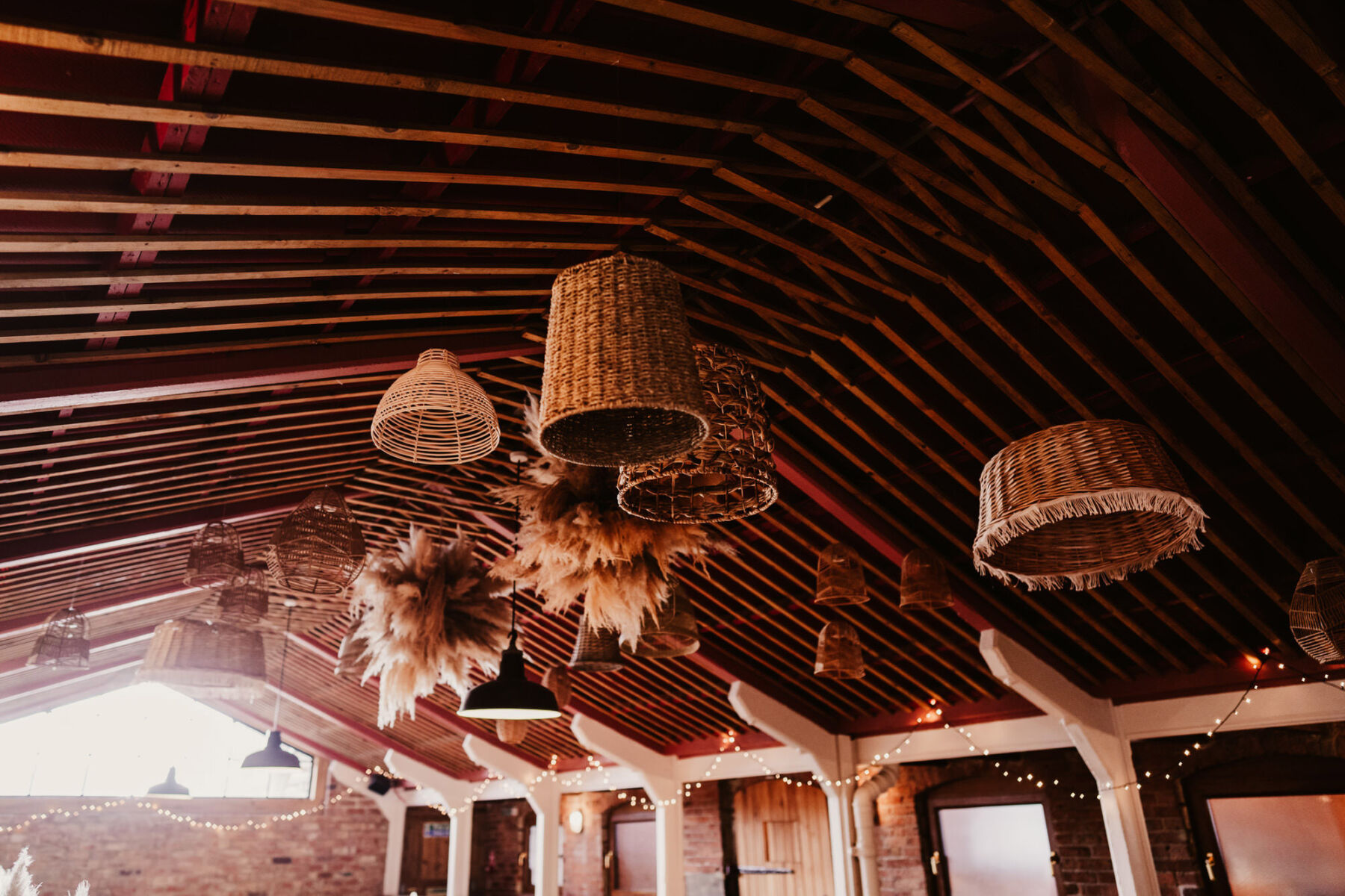 Ratton lampshades hanging from ceiling. Bohemian wedding decor.
