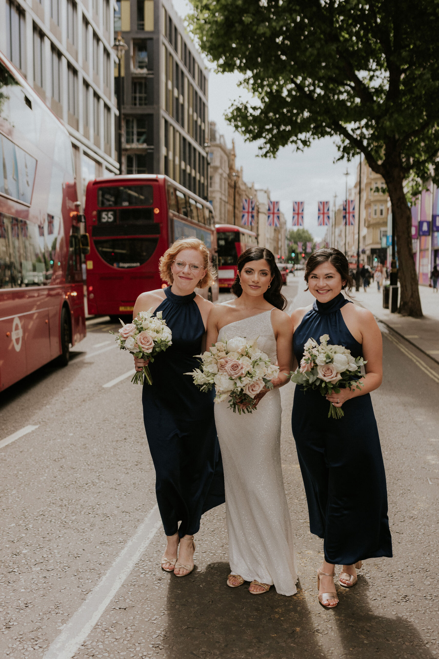 Bridesmaids in navy blue halterneck dresses. Wedding bouquets by Mary Jane Vaughan. Bride in Jenny Yoo sequin wedding dress