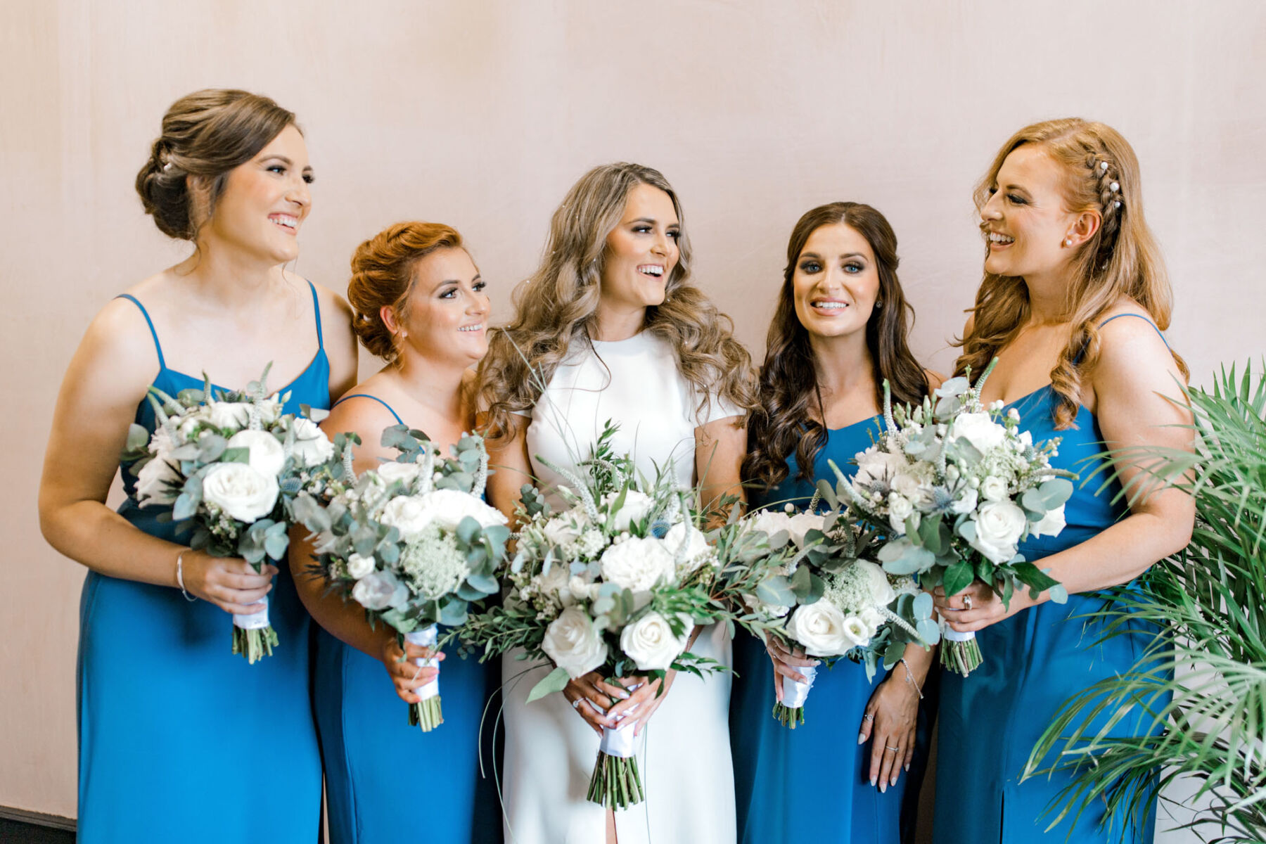 Bride with bridesmaids in blue, carrying Eucalyptus bouquets