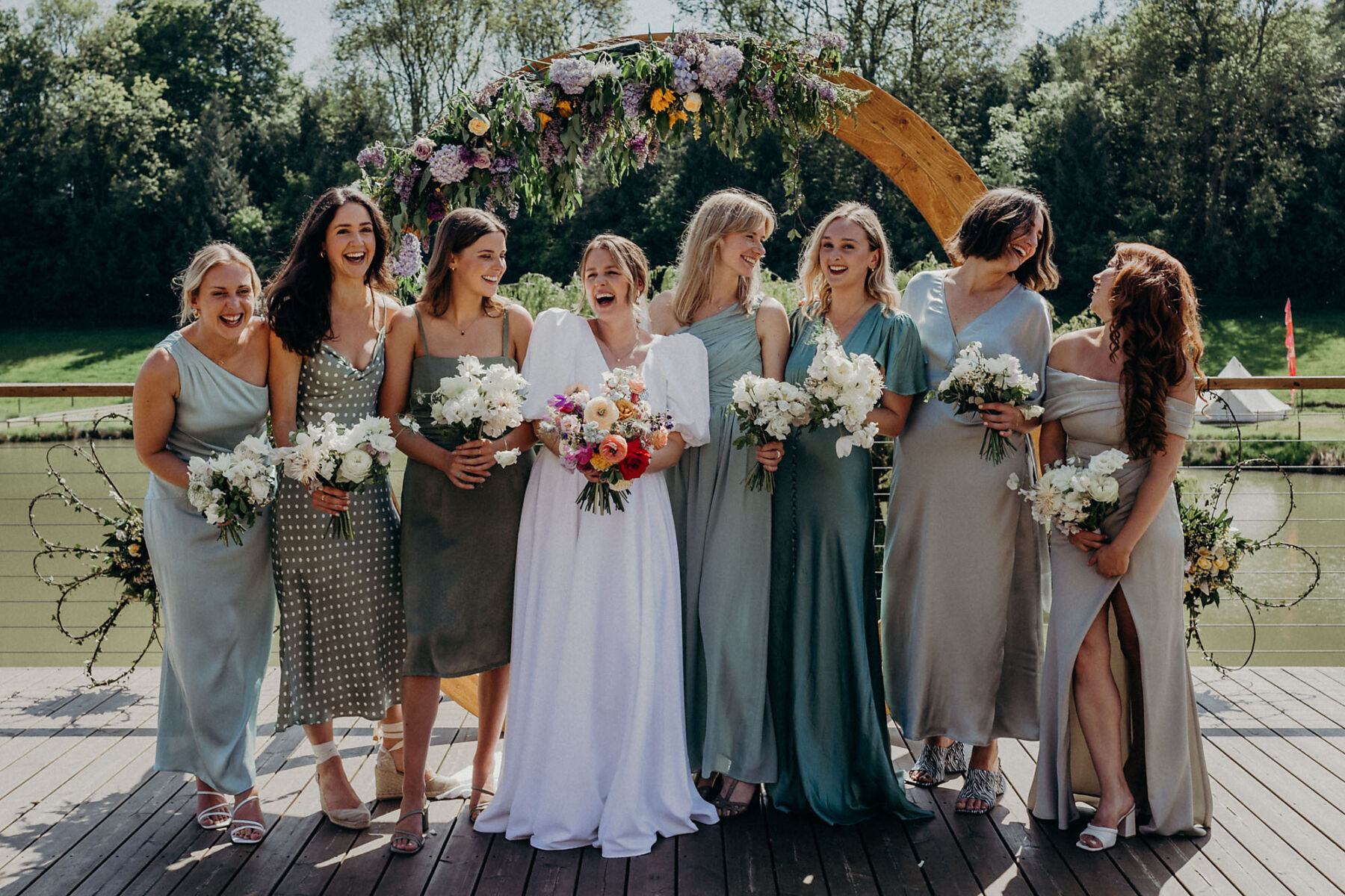 Bridesmaids in sage green dresses. Bride wearing & For Love.