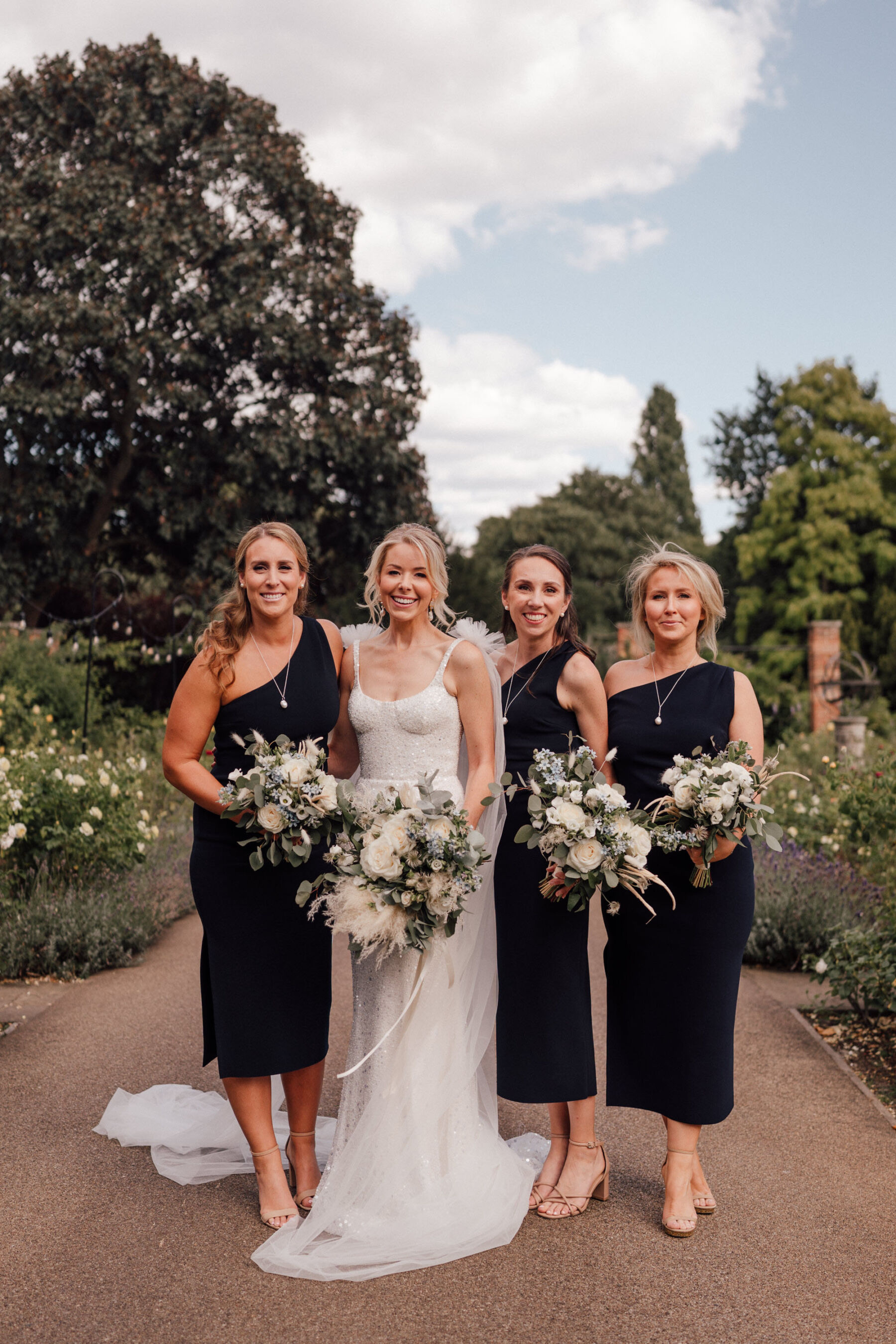 Bridesmaids in black, asymmetrical Bec & Bridge one shoulder wedding dresses