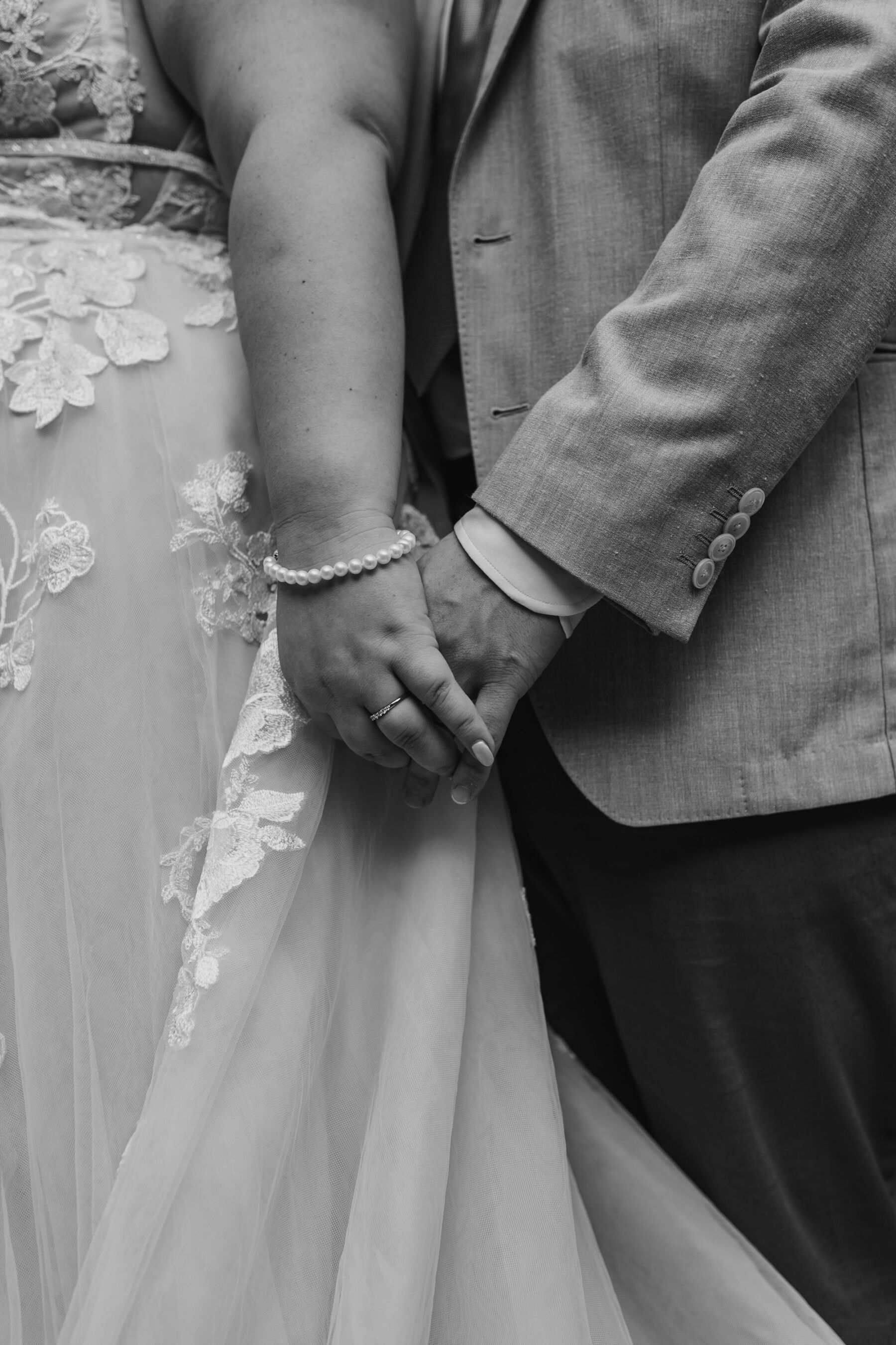 Close up shot of bride & groom holding hands
