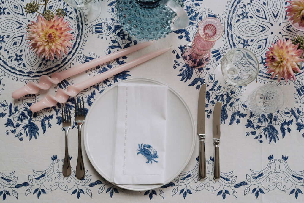 Pink tapered candles, embroidered napkins & modern tableware