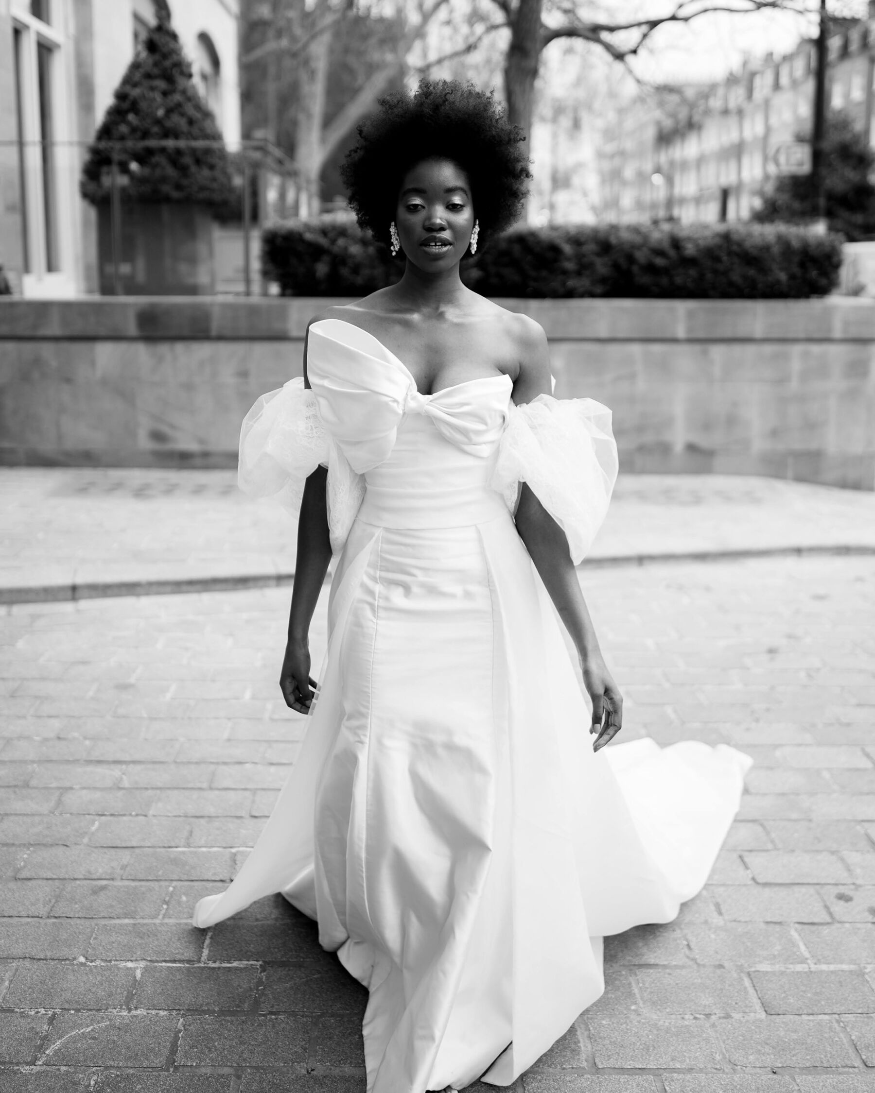 Black bride with afro wearing Sally Bean Couture wedding dress with large bows front and back
