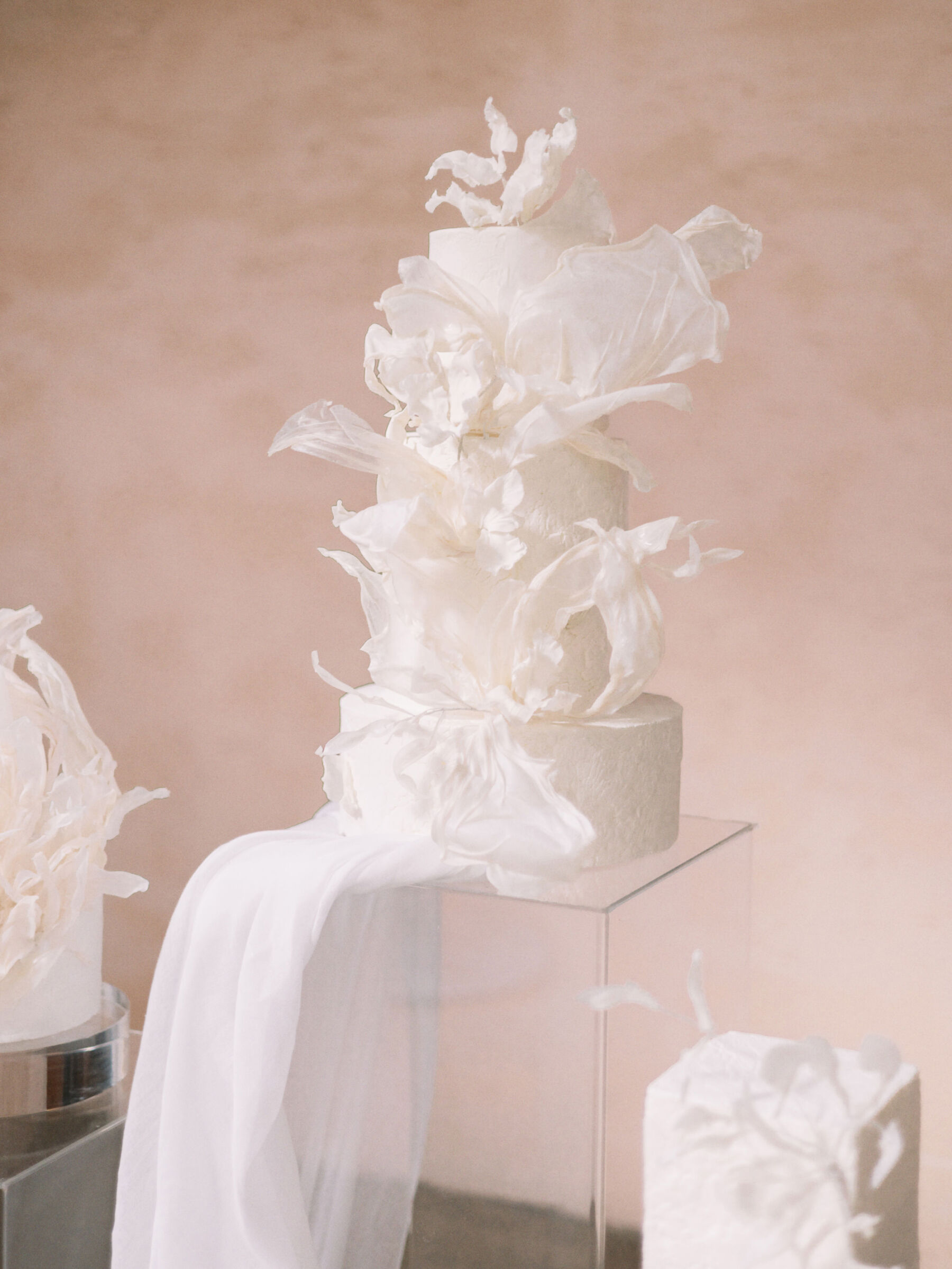 Dramatic 4 tier wedding cake in the shape of falling fabric.